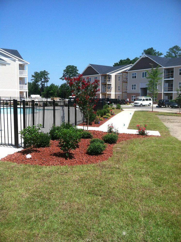 A fenced in area with a swimming pool in the background