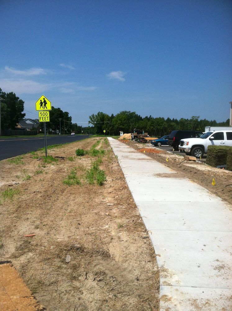 A concrete walkway is being built next to a road