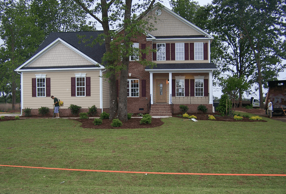 A house with a large lawn in front of it