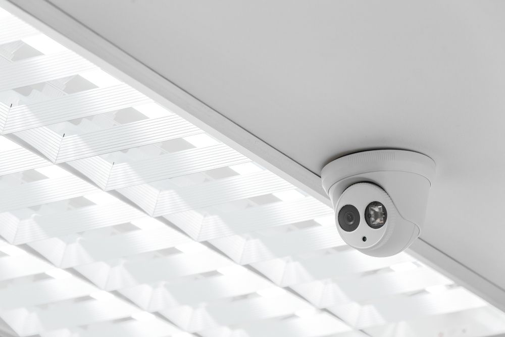 A Security Camera Is Mounted on The Ceiling of A Building — T.N. Locke Communications In Townsville, QLD