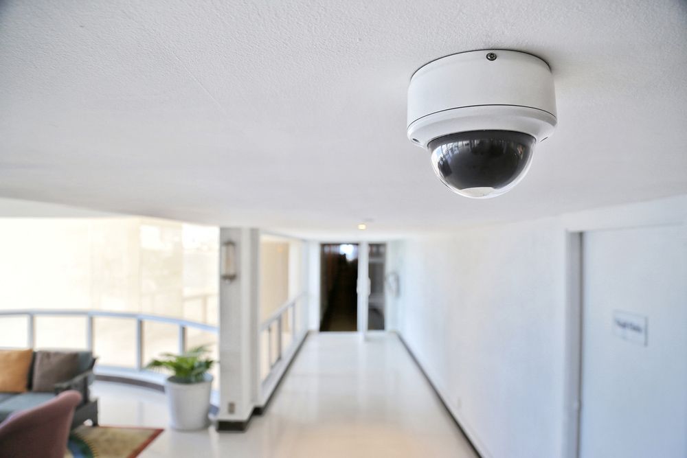 A Security Camera Is Hanging from The Ceiling of A Hallway — T.N. Locke Communications In Kirwan, QLD