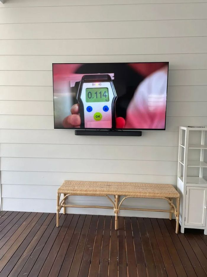 A Flat Screen Tv Is Hanging on A Wall Above a Wooden Bench — T.N. Locke Communications In Kirwan, QLD