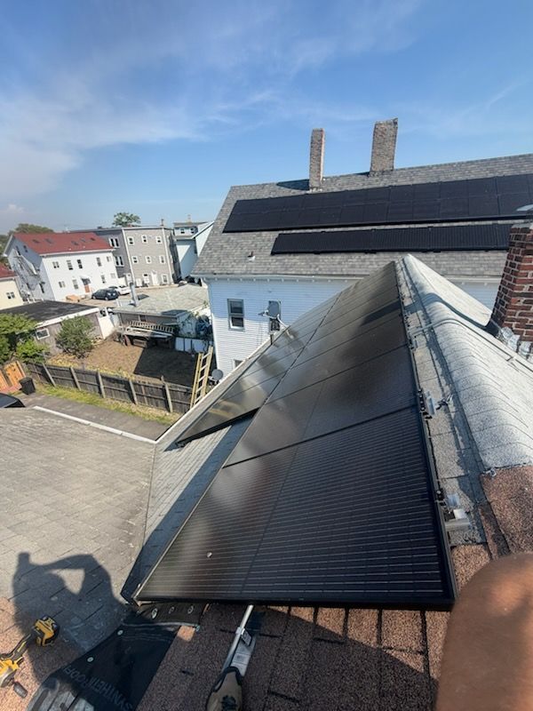 Rooftop with solar panels overlooking a residential neighborhood on a sunny day