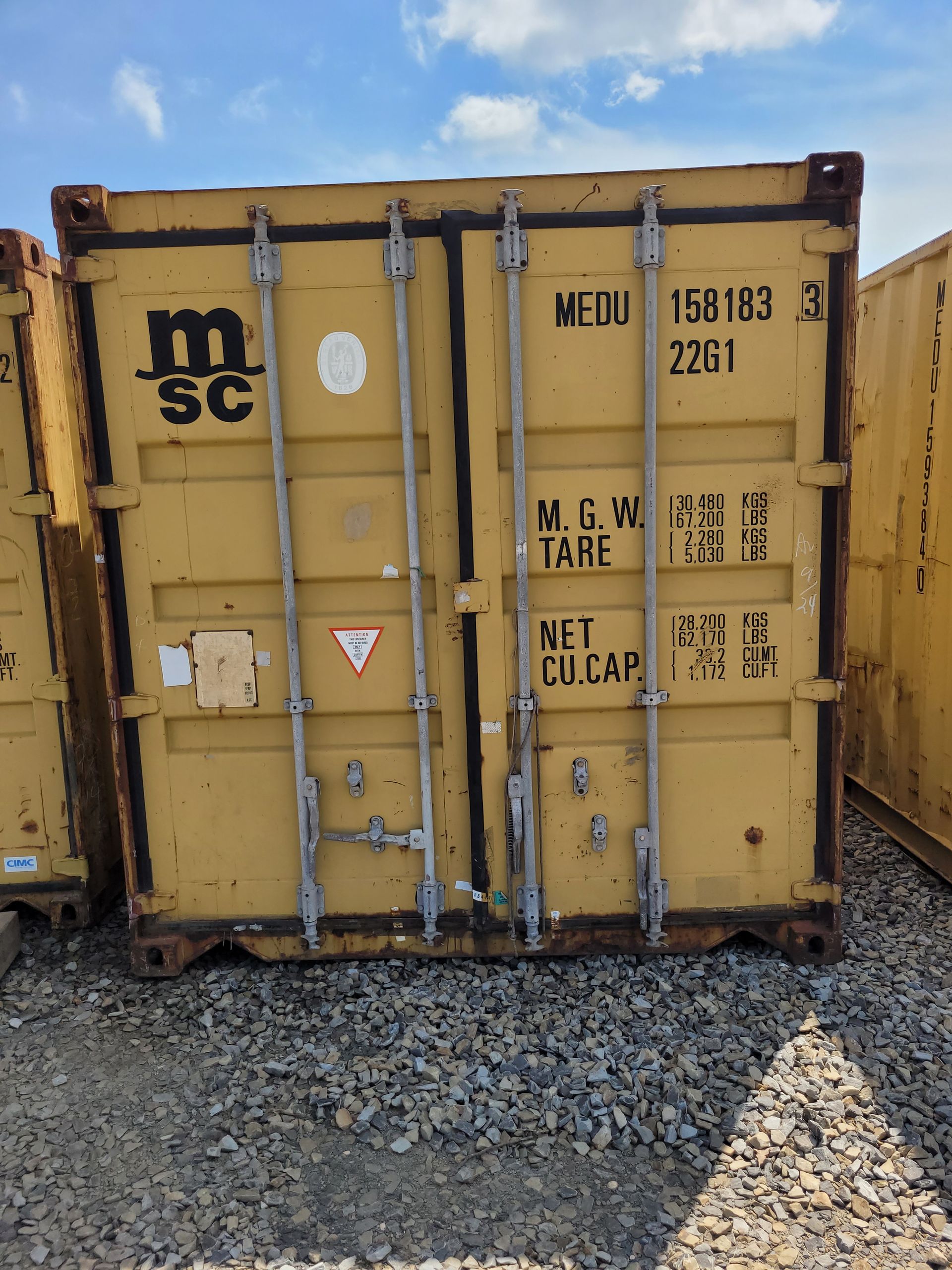 A yellow shipping container with the letter m on it