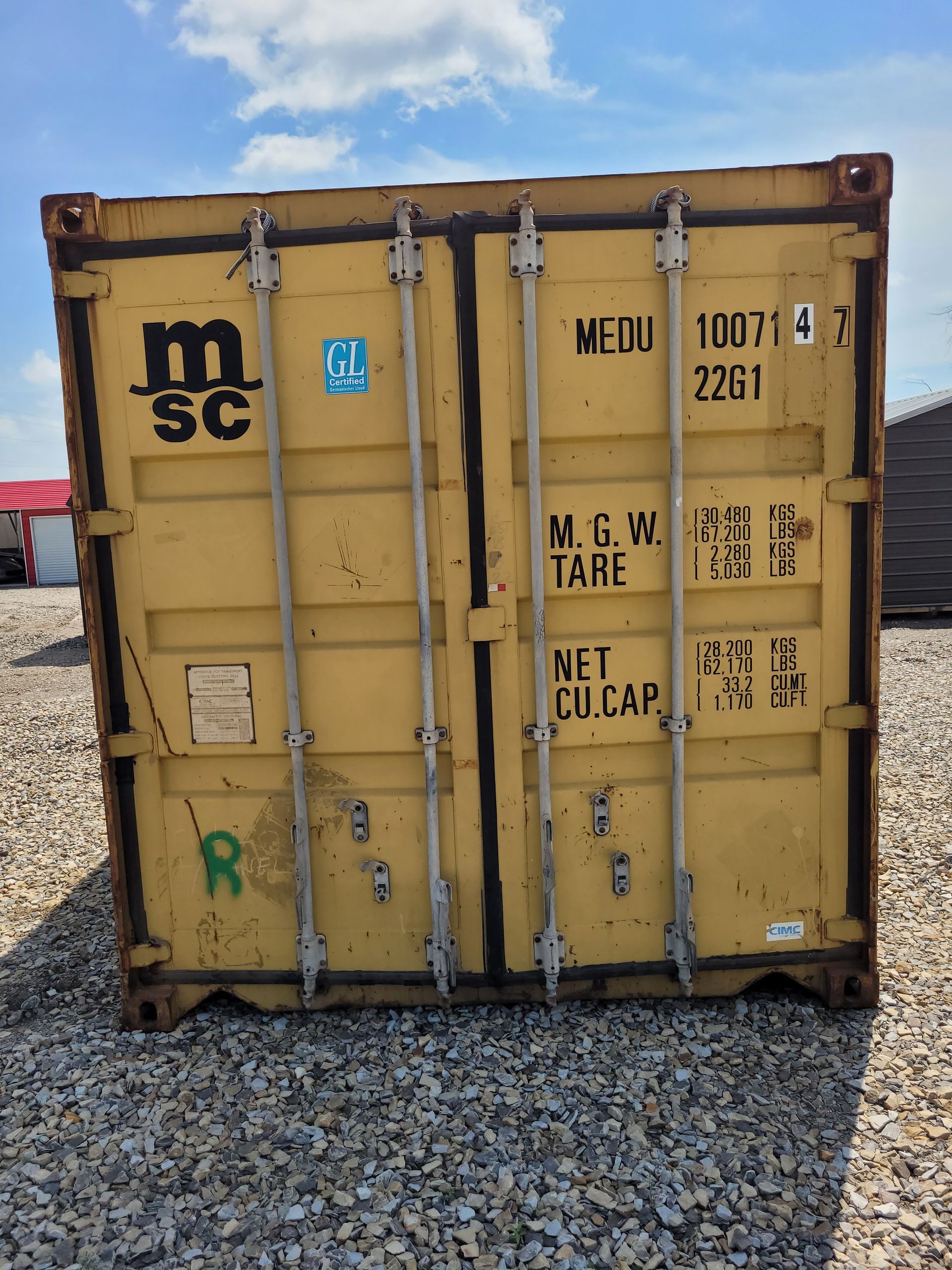 A yellow shipping container with the letter m on it