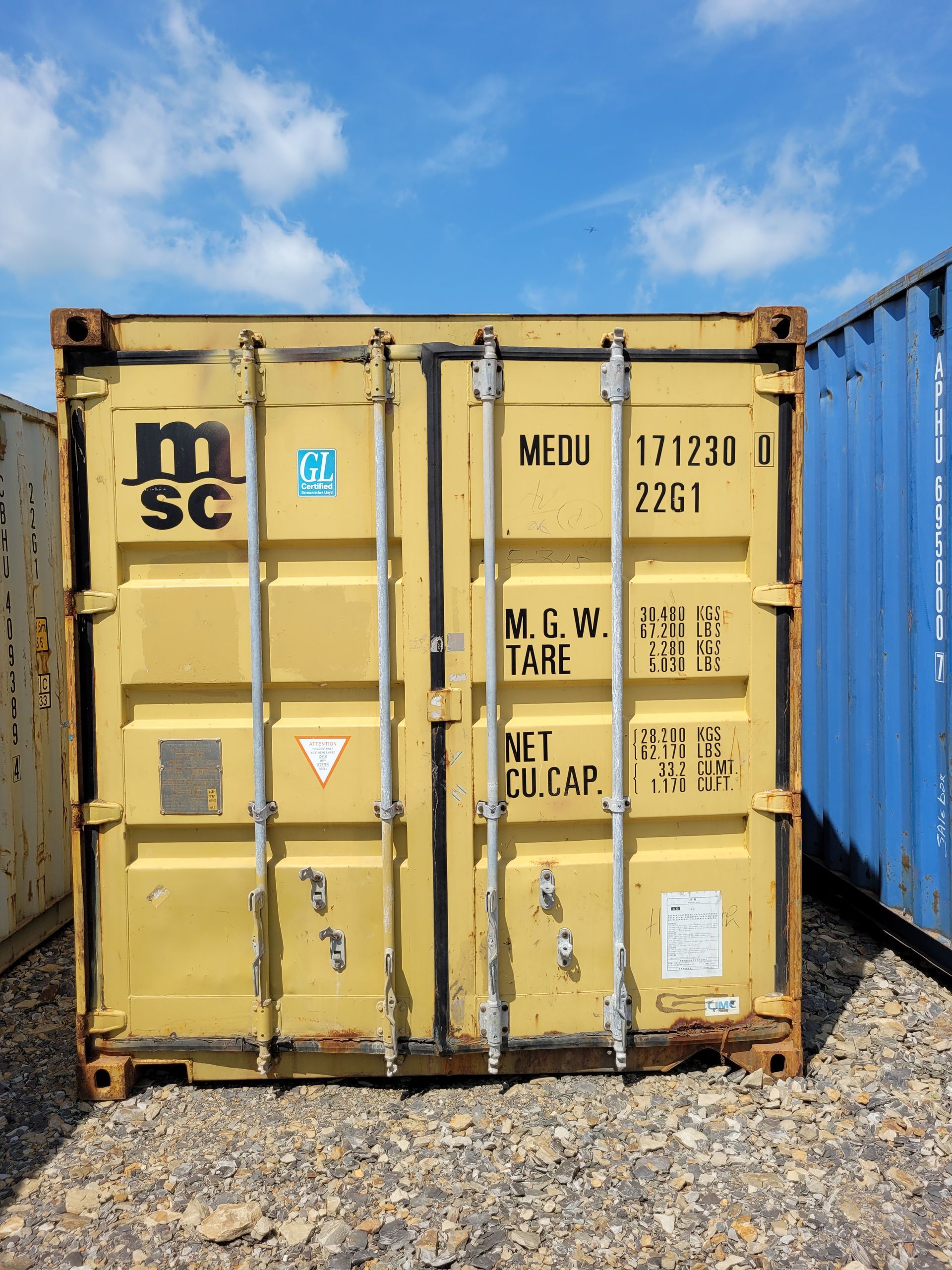 A yellow shipping container with the letter m on it