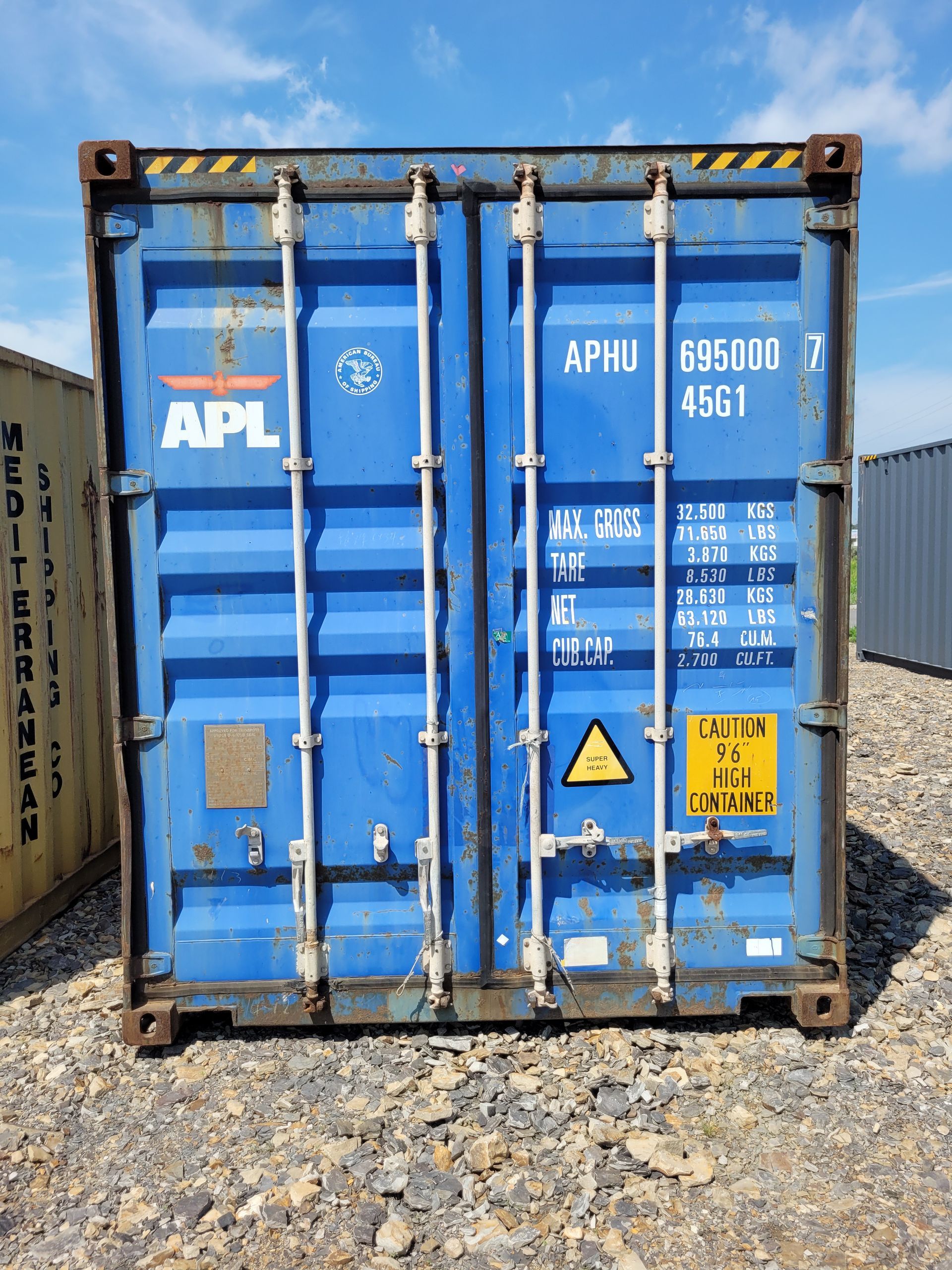 A blue shipping container with the word apl on it