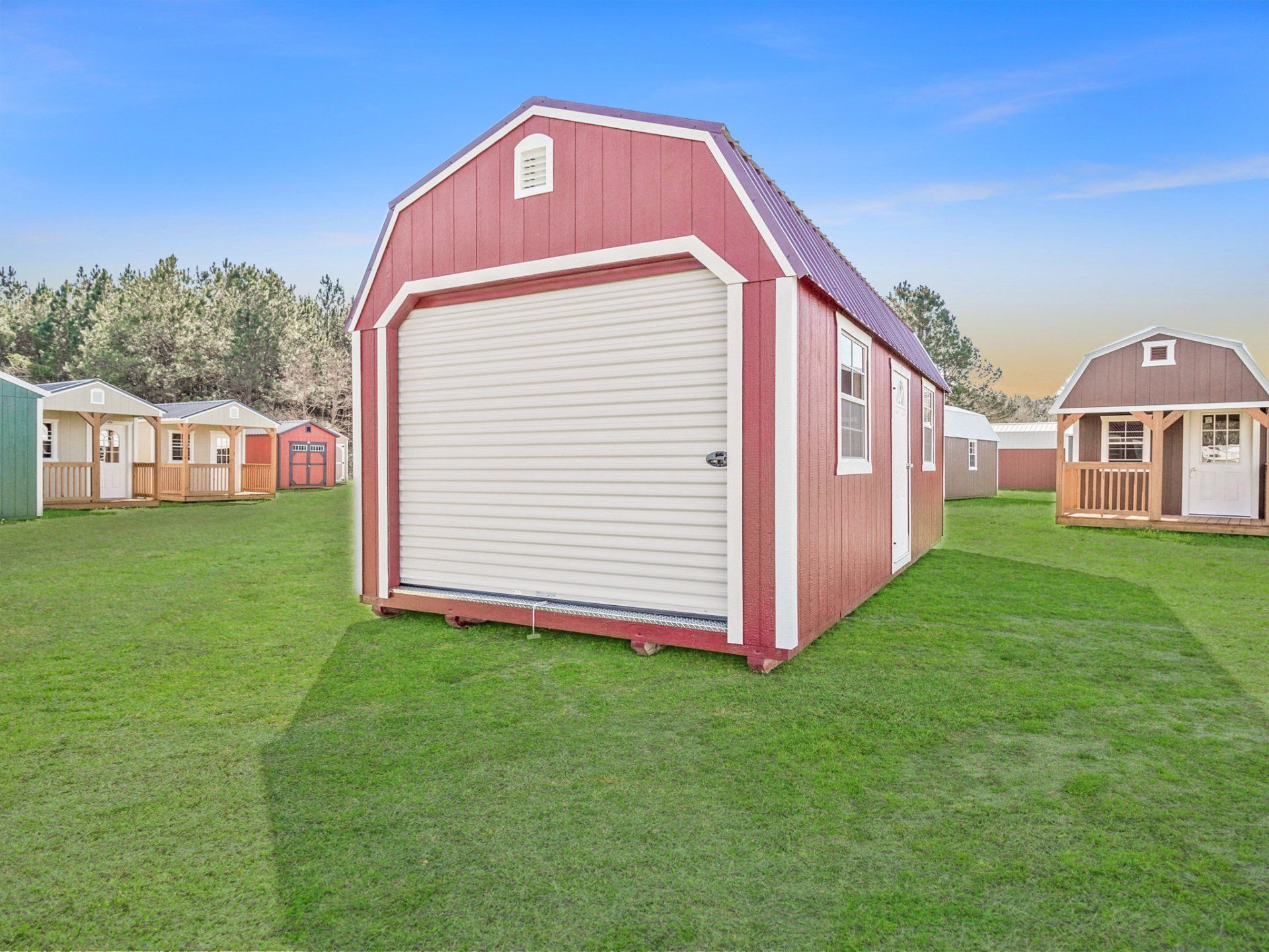Superior Outdoor Centers portable lofted garage A red barn with a white door is sitting on top of a lush green field.
