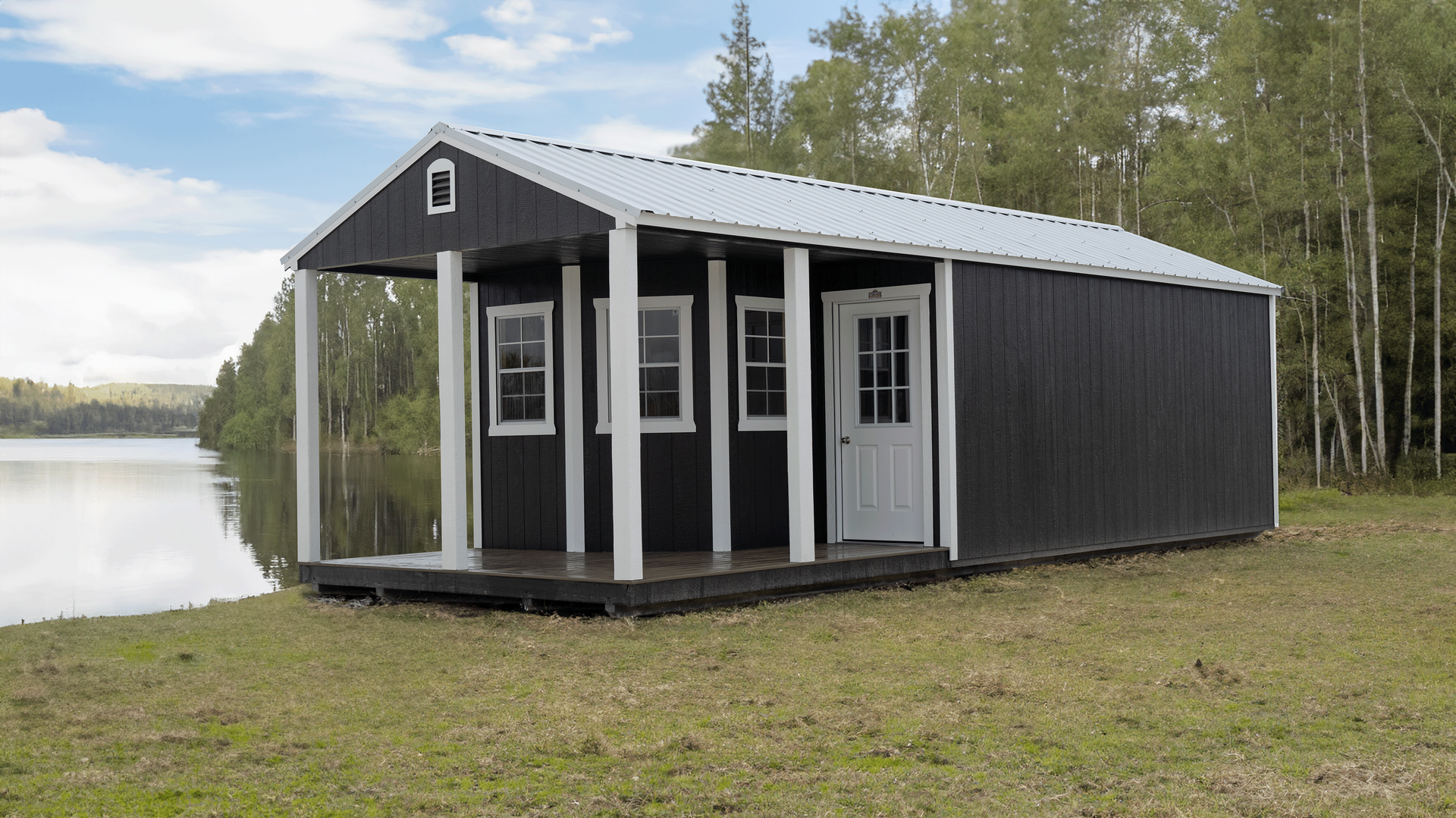 Superior Outdoor Centers  deluxe cabin A small black shed with a porch next to a lake.