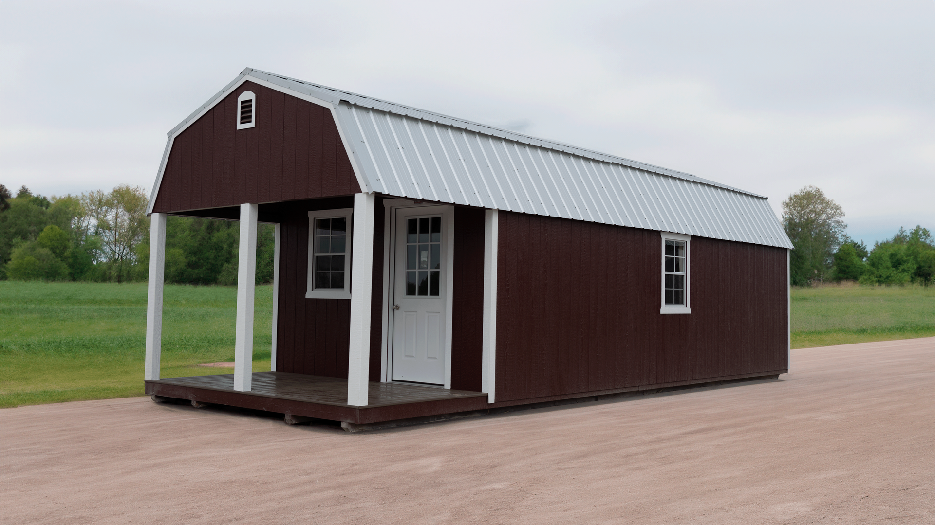 Superior Outdoor Centers lofted barn cabin A brown barn with a porch is sitting on top of a dirt road.