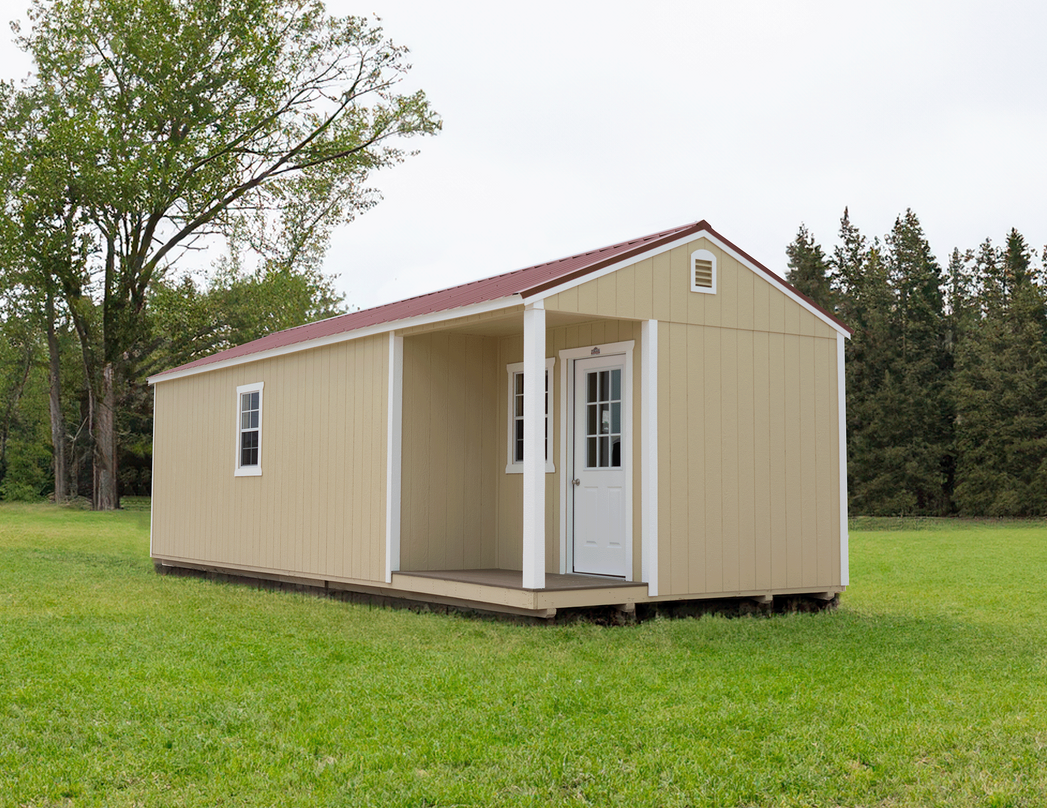 Superior Outdoor Centers  side cabin A small house with a porch is sitting in the middle of a grassy field.
