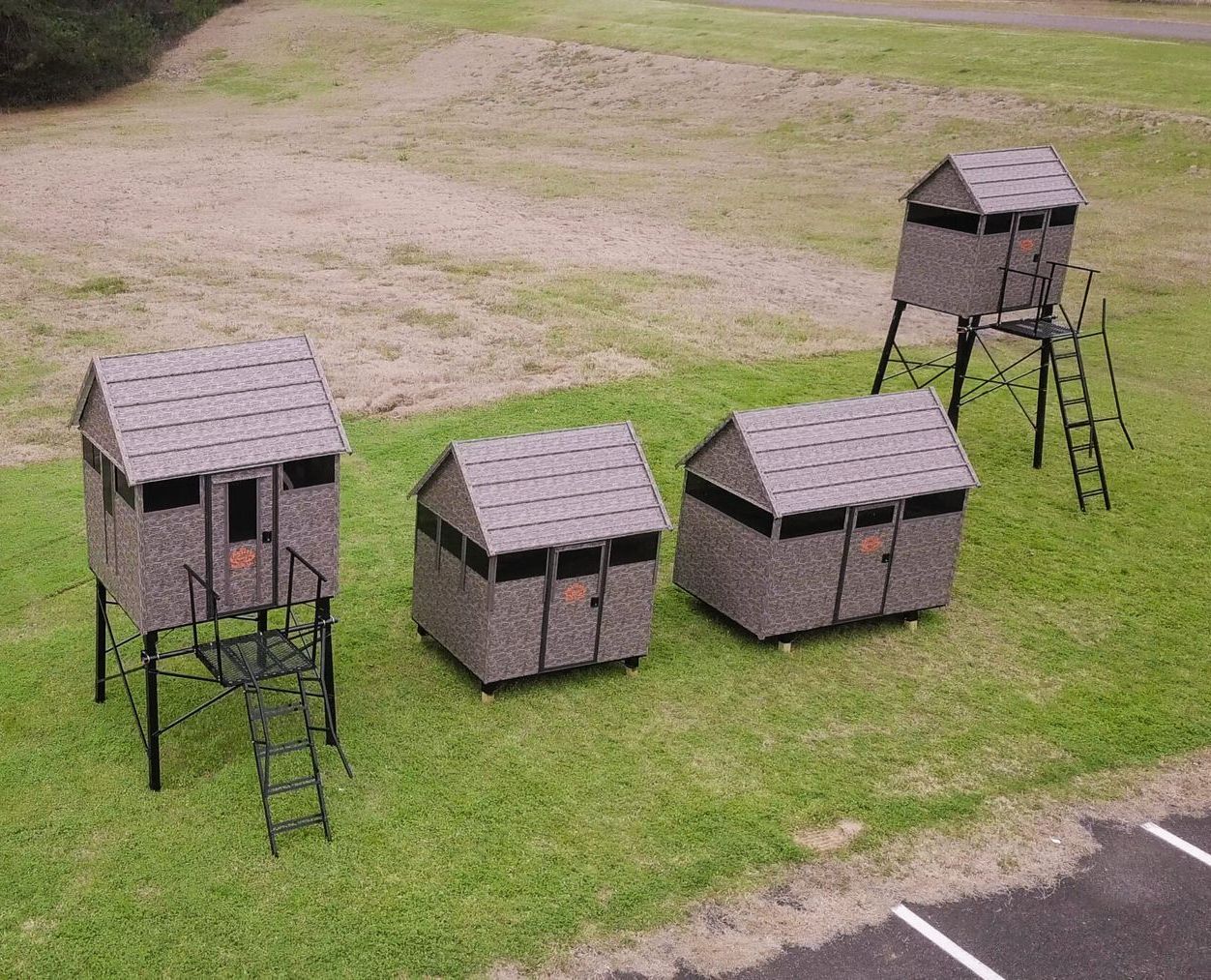 Superior Outdoor Centers deer blinds A group of small houses are sitting on top of a lush green field.