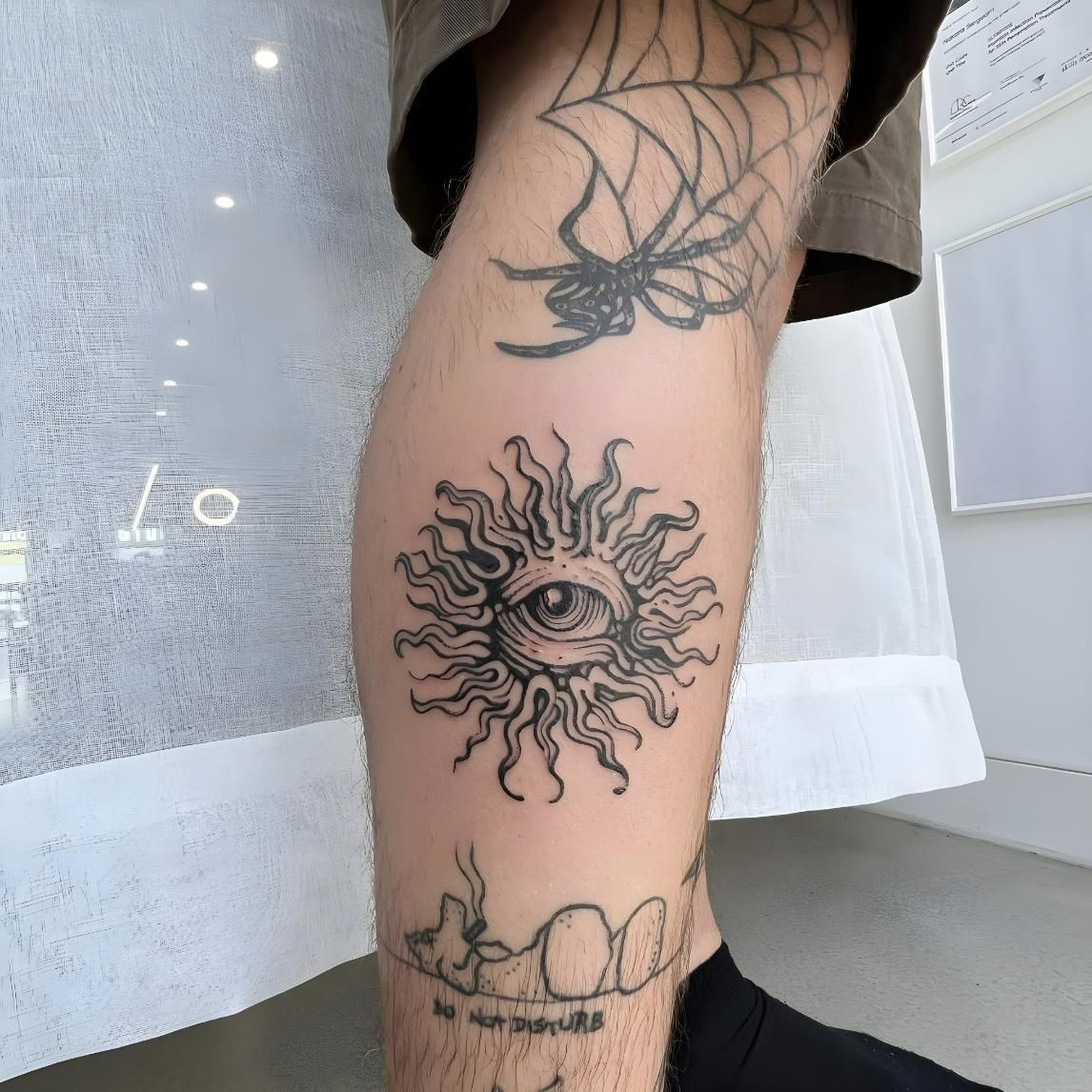 Leg With Tattoos: Spider, Sun With Eye, And Teeth — Tattoo Inc Studio In Broadbeach, QLD