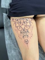 Forearm and hand with a black star tattoo, resting on a chair in an indoor setting