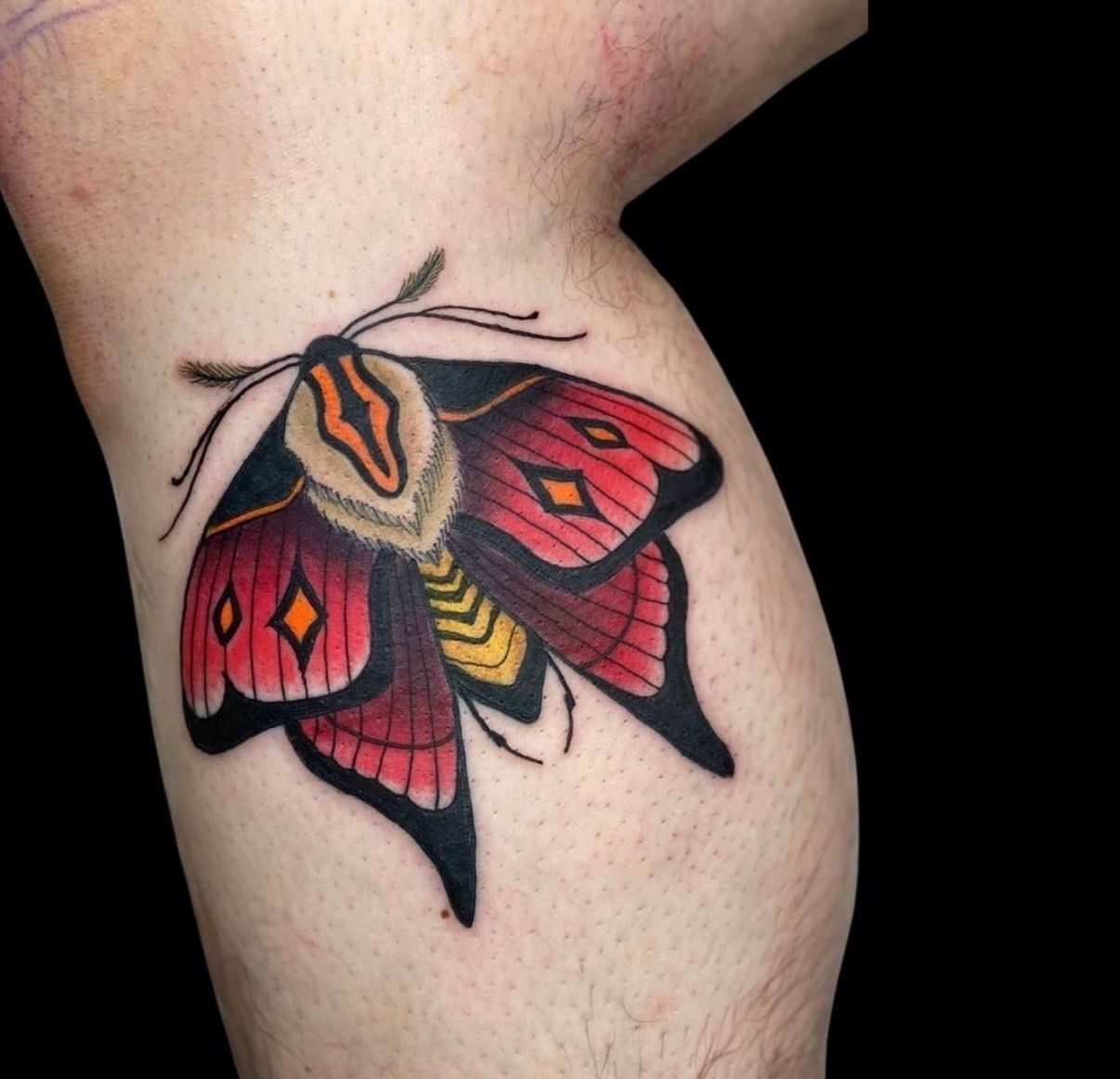 Colourful Moth Tattoo With Red, Orange, and Black Wings on Skin — Tattoo Inc Studio In Broadbeach, QLD