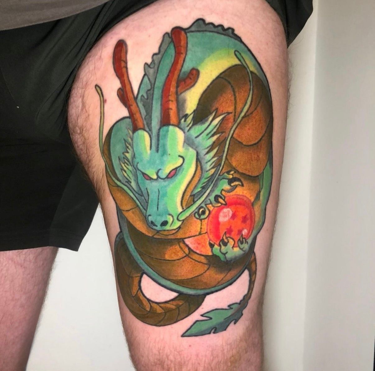 Colourful Dragon Tattoo on a Thigh, With Green Face — Tattoo Inc Studio In Broadbeach, QLD