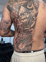 Person Showing a Large Black-and-gray Back Tattoo of a Fierce Mask — Tattoo Inc Studio In Broadbeach, QLD