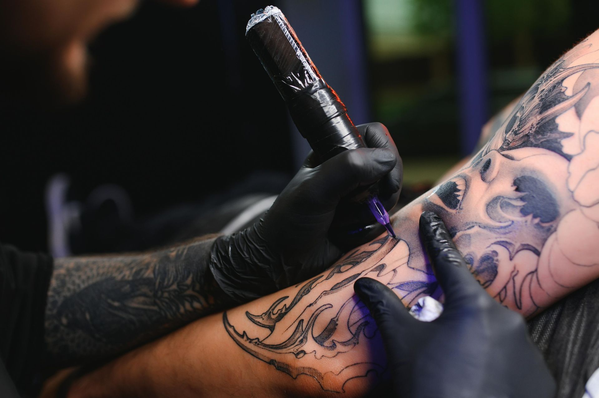 Tattoo Artist In Black Gloves, Using A Tattoo Gun To Ink A Detailed Design — Tattoo Inc Studio in Burleigh, QLD