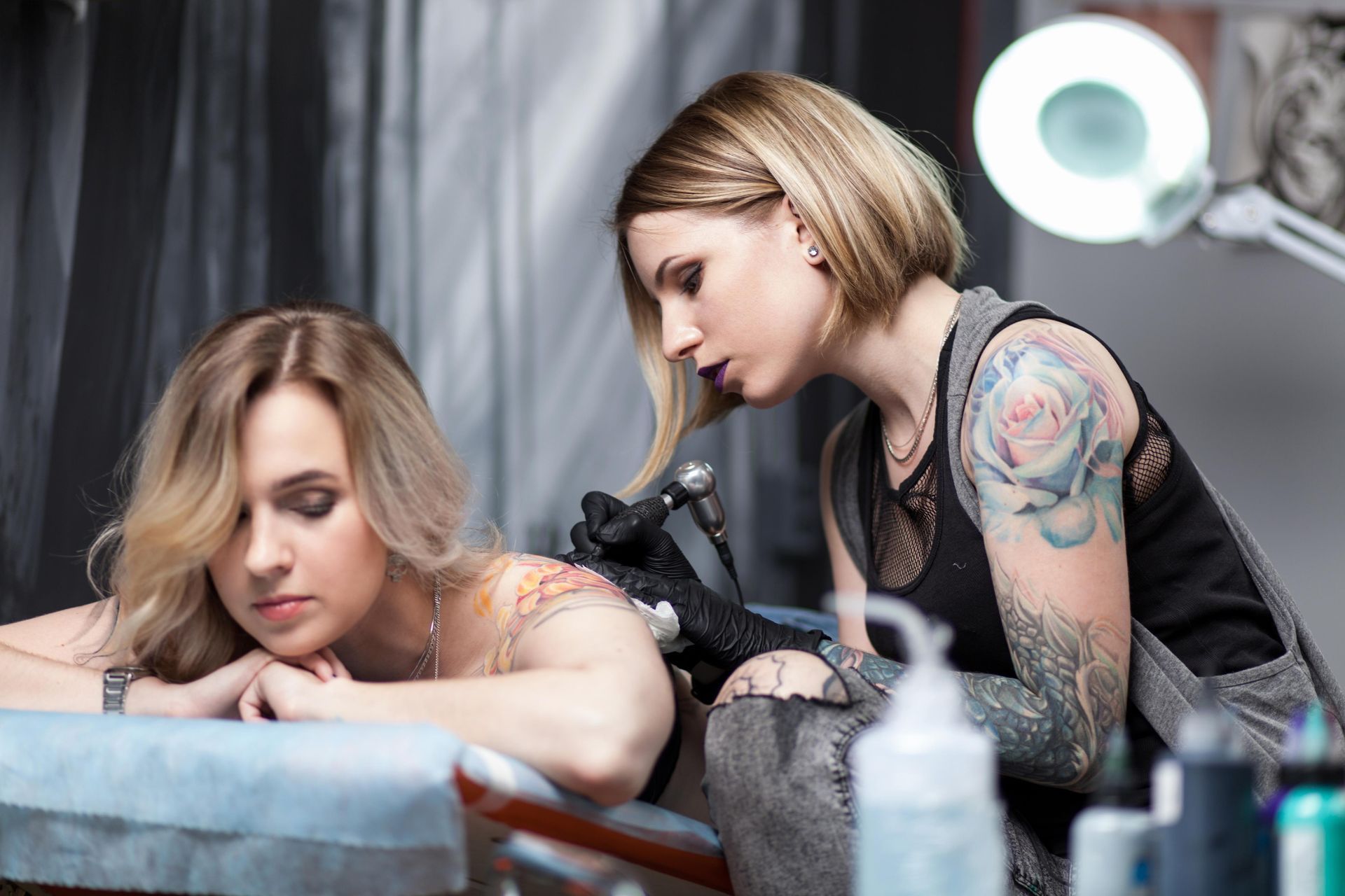 Woman Getting Tattooed On Her Back By A Tattoo Artist In A Studio; The Artist Has Tattoos — Tattoo Inc Studio in Robina, QLD