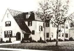 Black-and-white photo of a large old house with trees and a car parked in front
