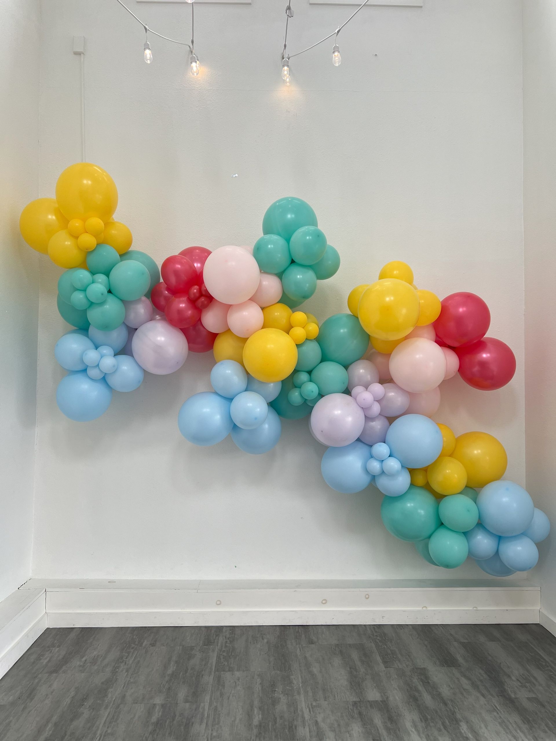 a bunch of balloons are hanging on a wall in a room