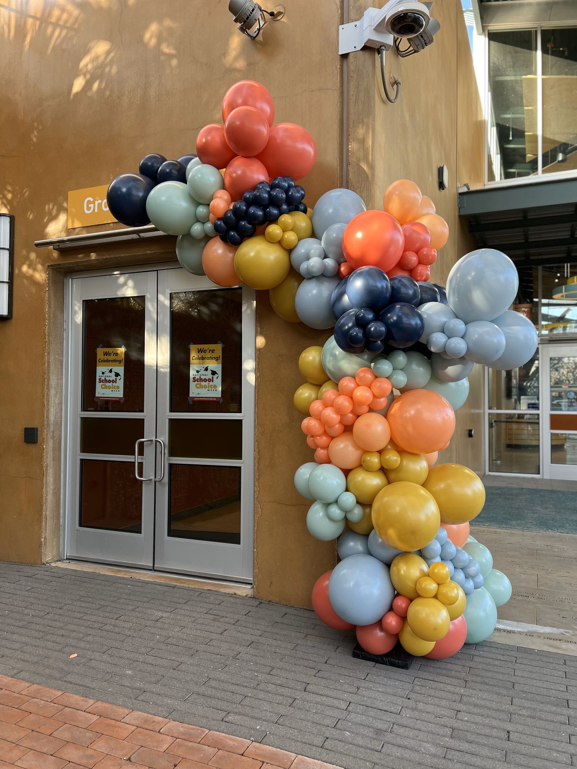 a bunch of balloons are hanging outside of a building
