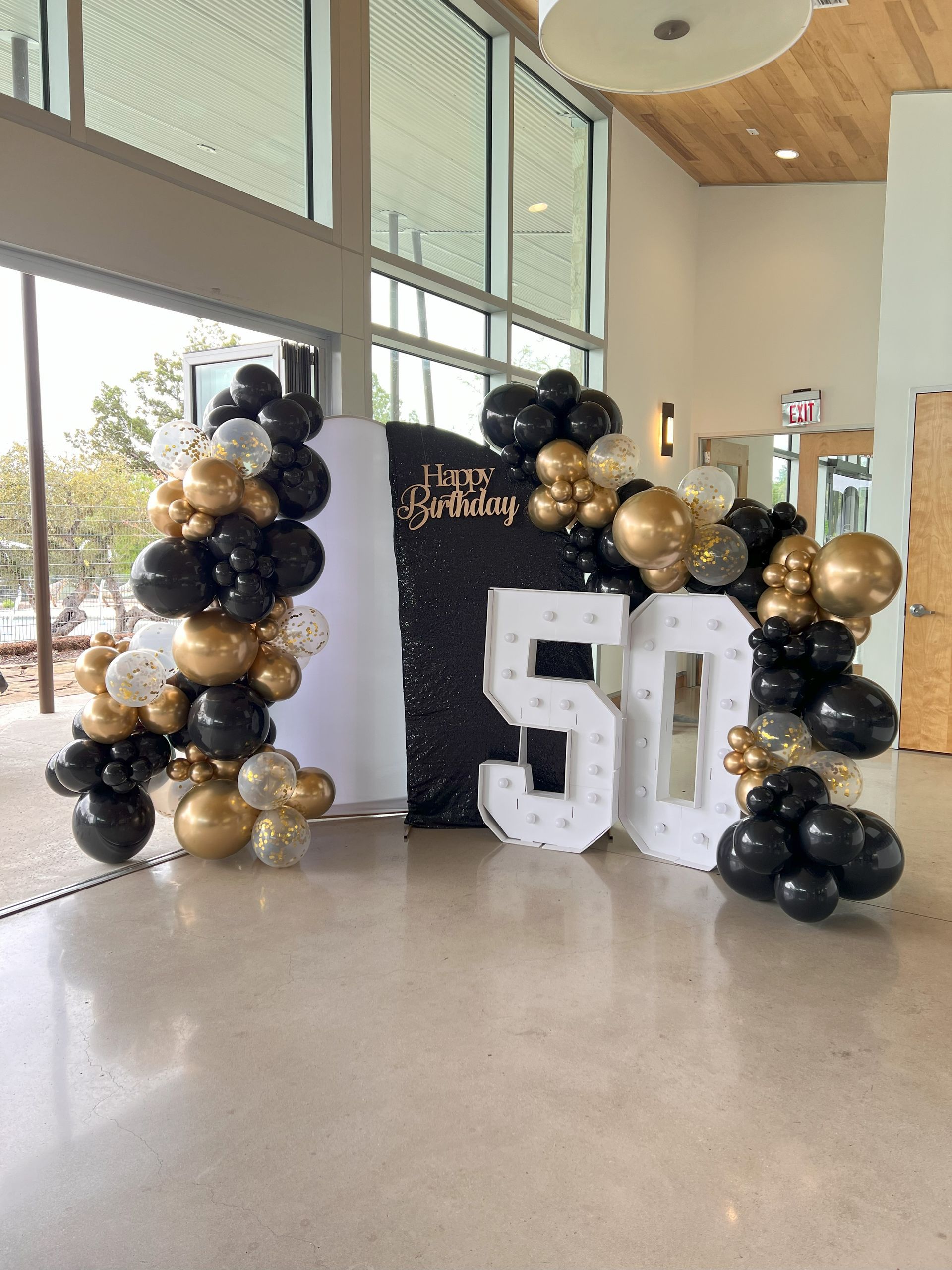 A room filled with balloons and a sign that says 50.