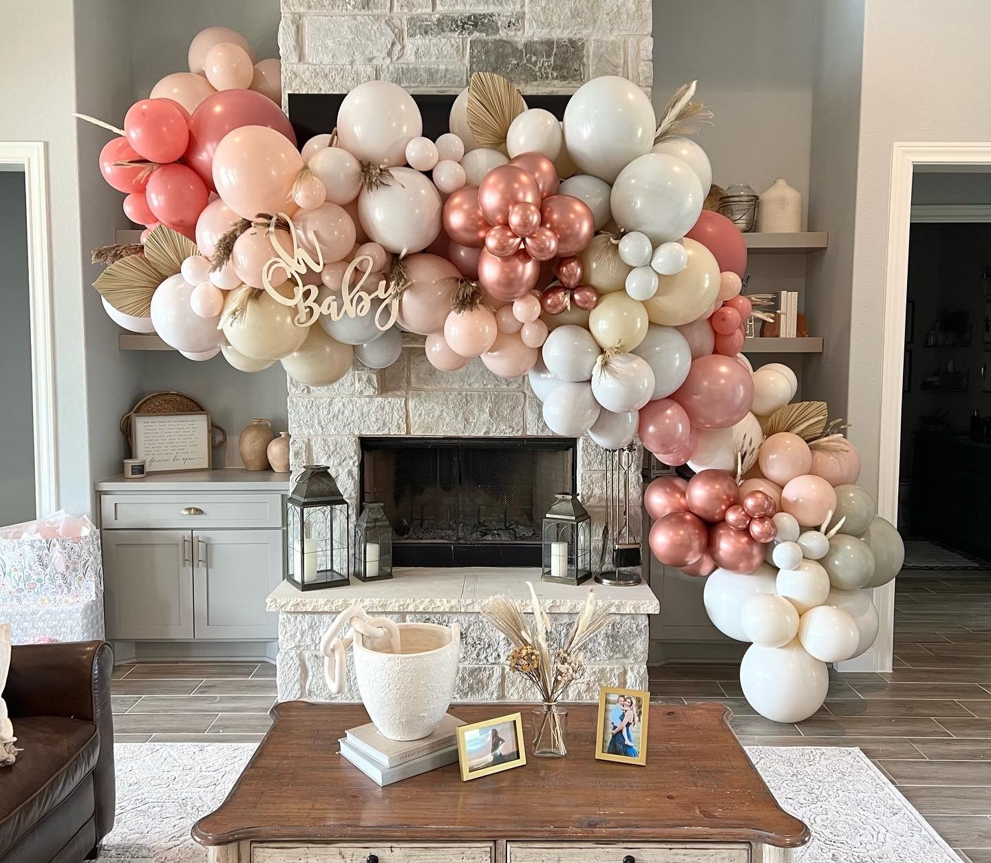 a living room with a fireplace decorated with balloons and a coffee table