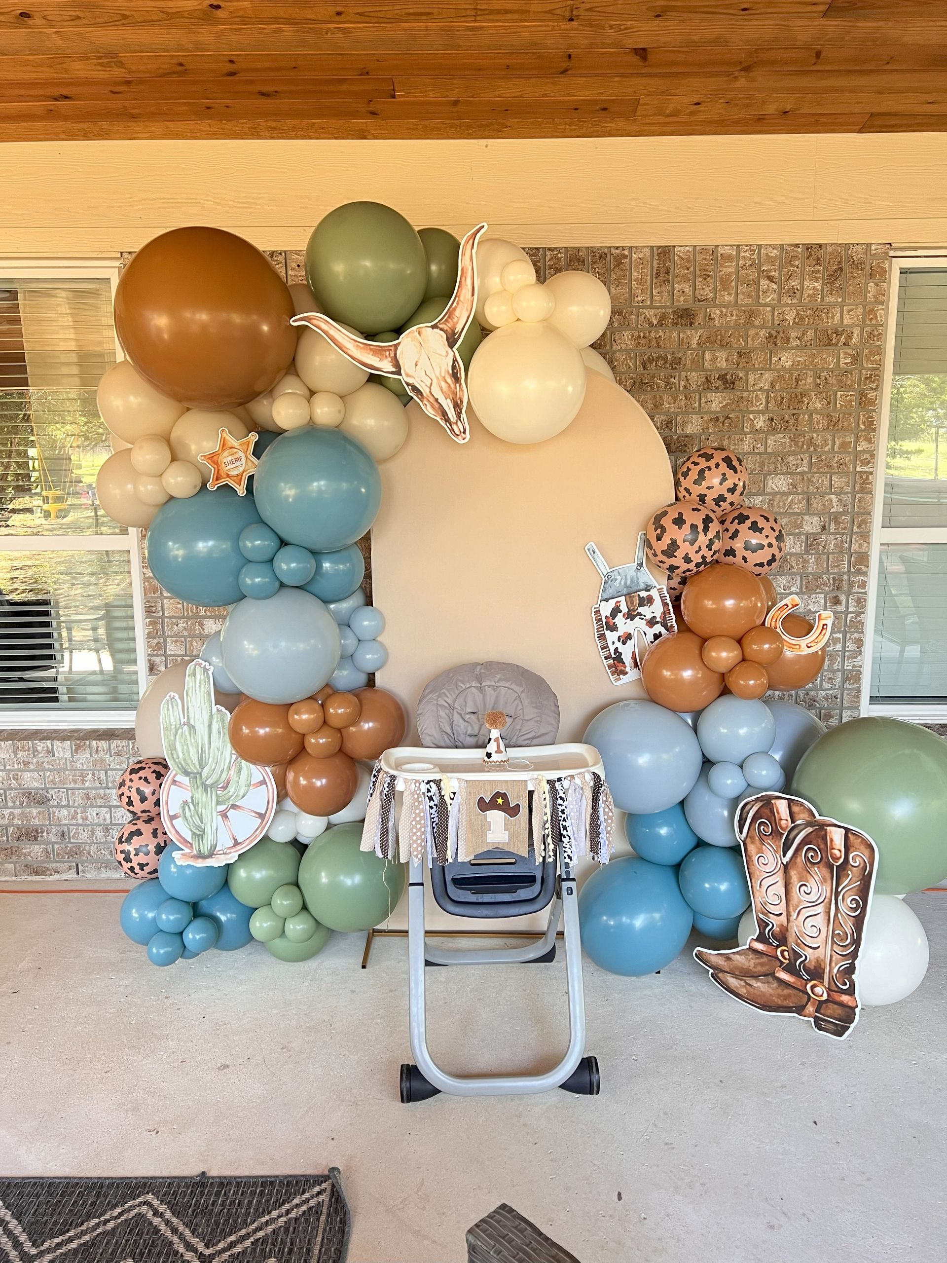 A high chair is decorated with balloons for a baby 's first birthday.