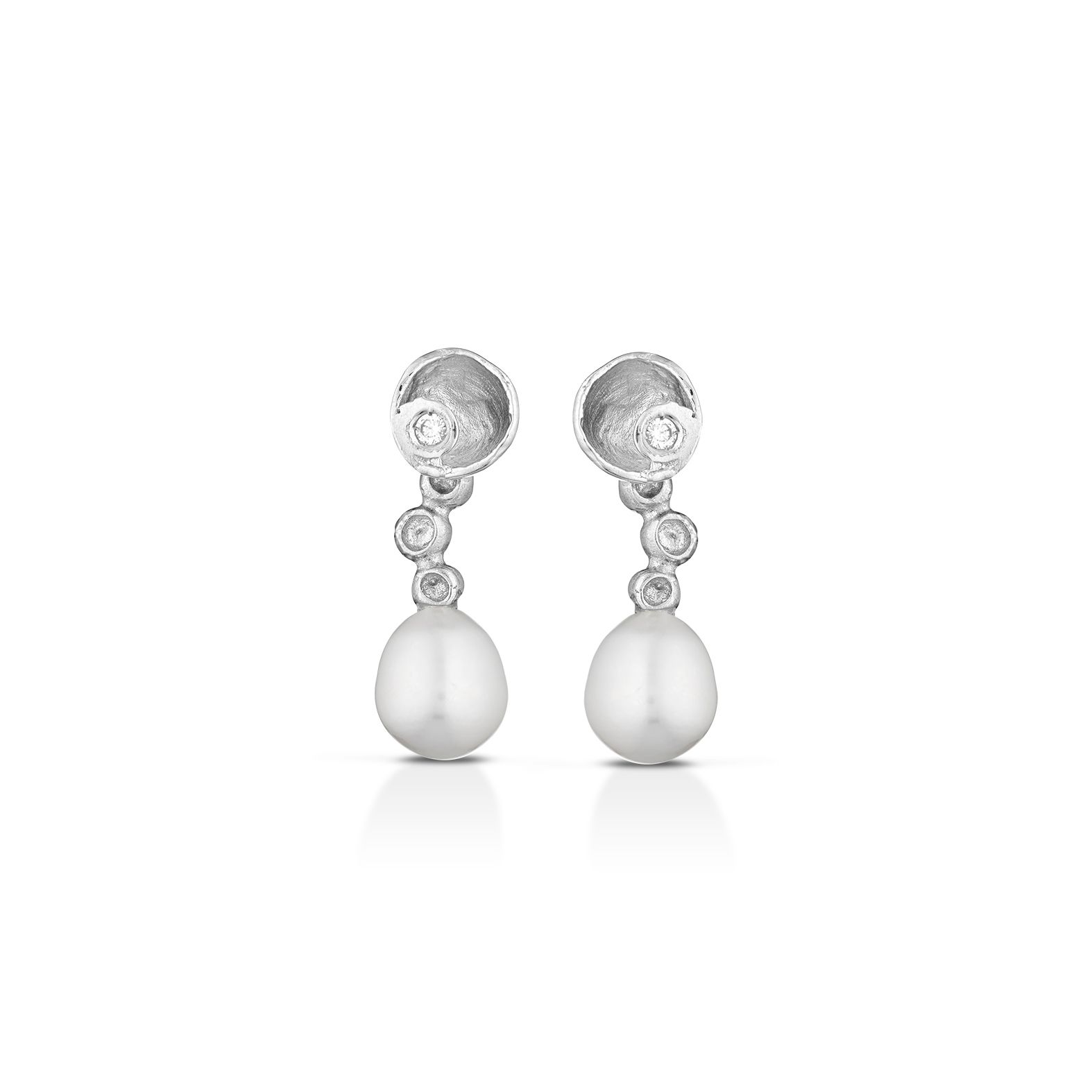 un paio di orecchini di perle e diamanti in oro bianco su sfondo bianco.
