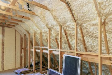 Interior of a framed room with spray foam insulation on walls and ceiling, unfinished construction site