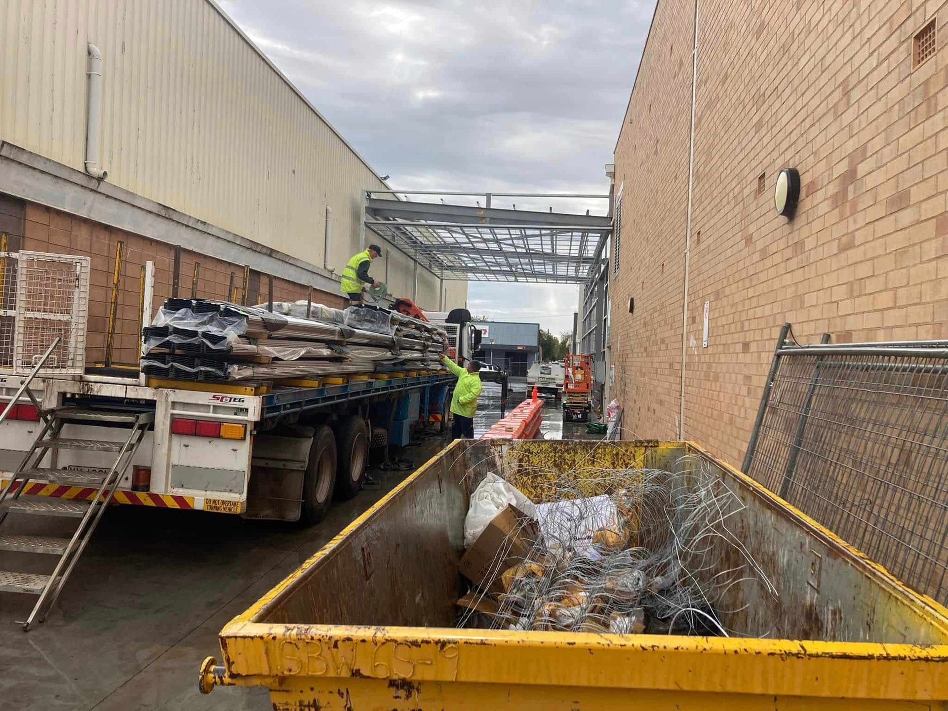Workers Loading Debris Into a Truck — SJ Moore Plumbing & Roofing in Wagga Wagga, NSW