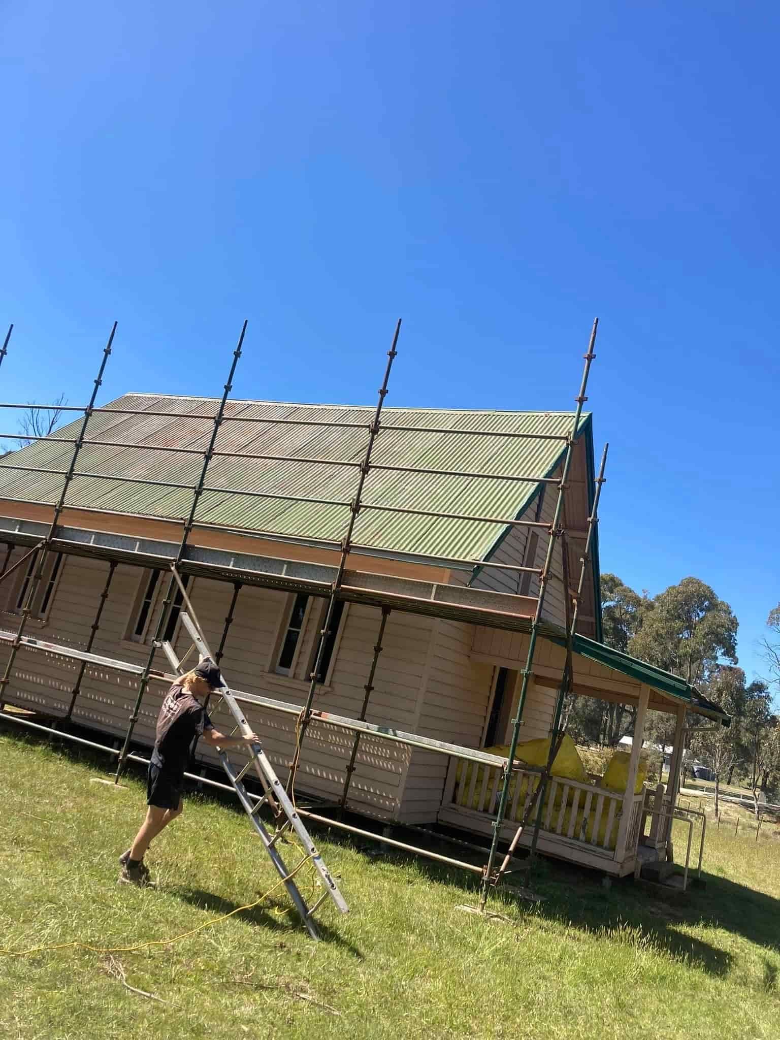 Person Carrying A Ladder — SJ Moore Plumbing & Roofing in Tumut, NSW