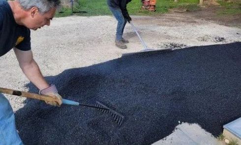 Crew performing asphalt repair and maintenance on a cracked driveway with professional equipment