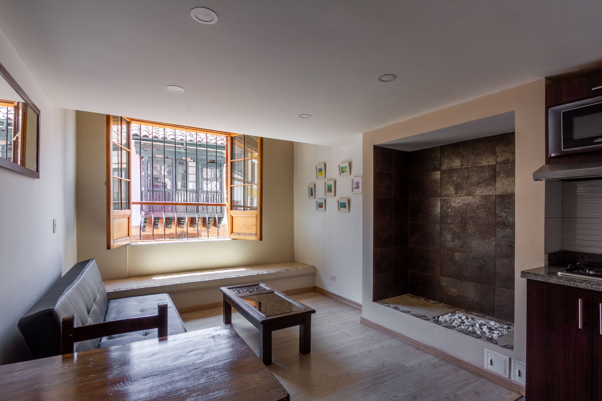 A living room with a couch , table , and window.