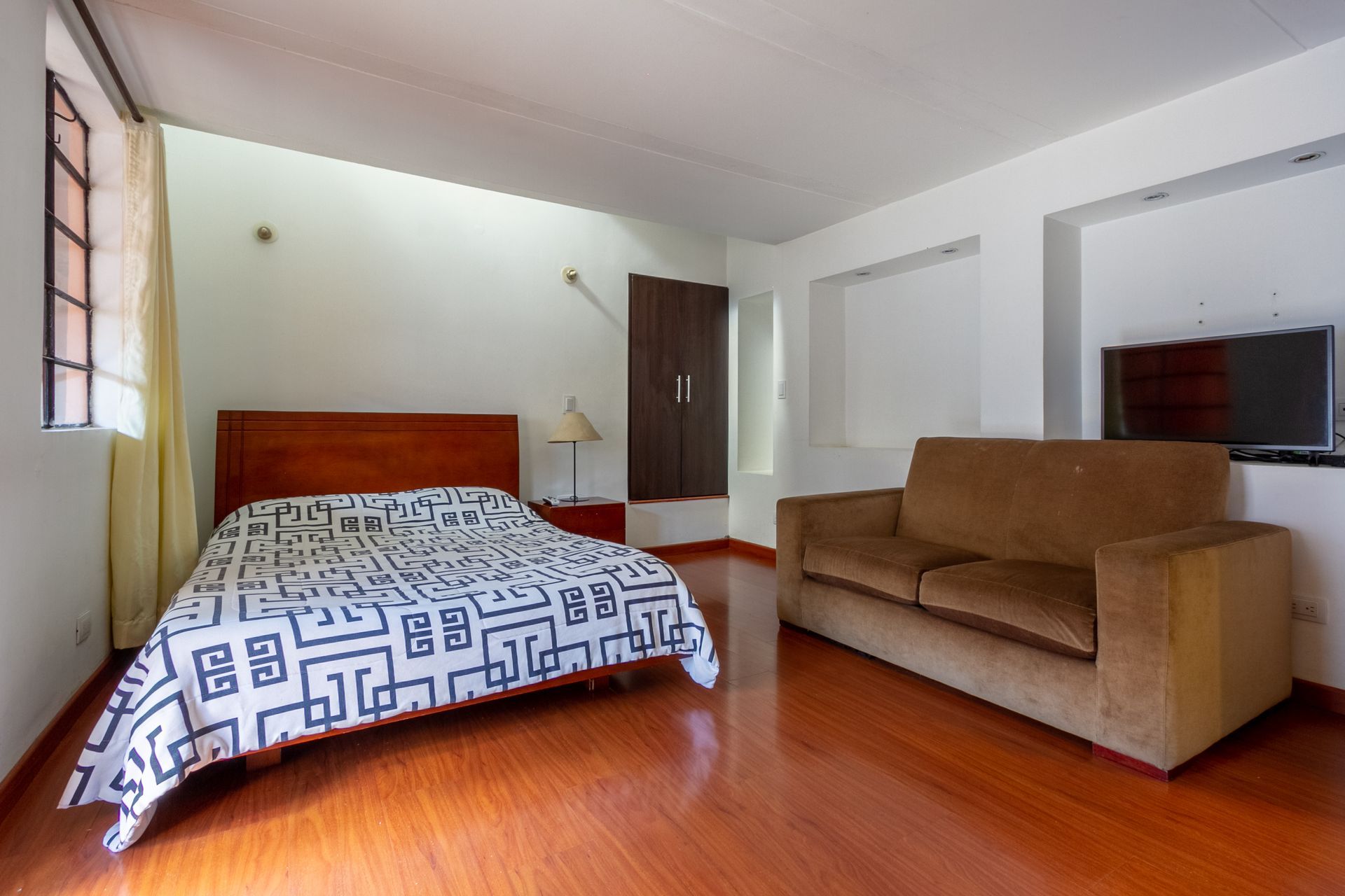There is a bed and a couch in the room.