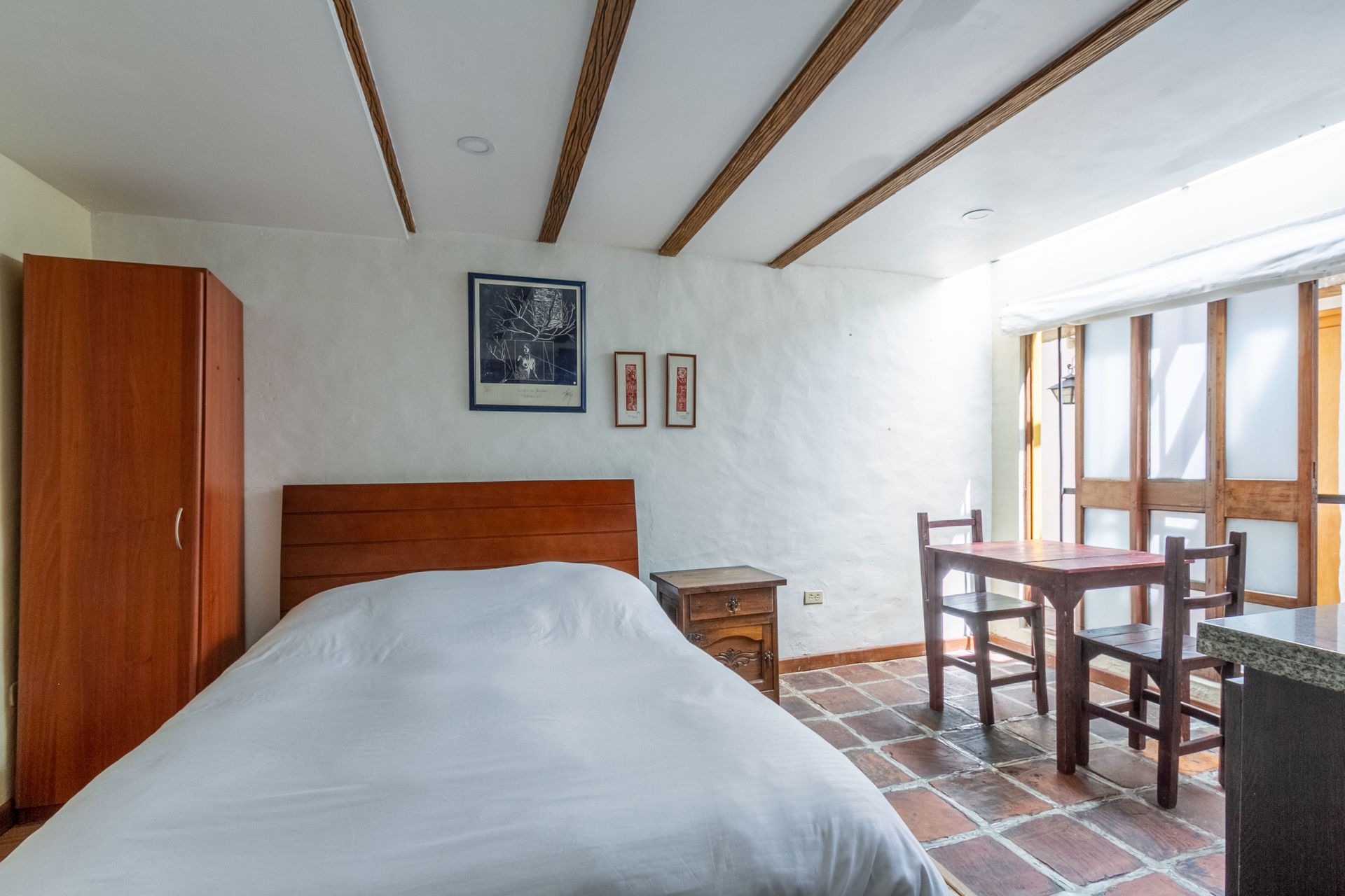 A bedroom with a bed , table and chairs
