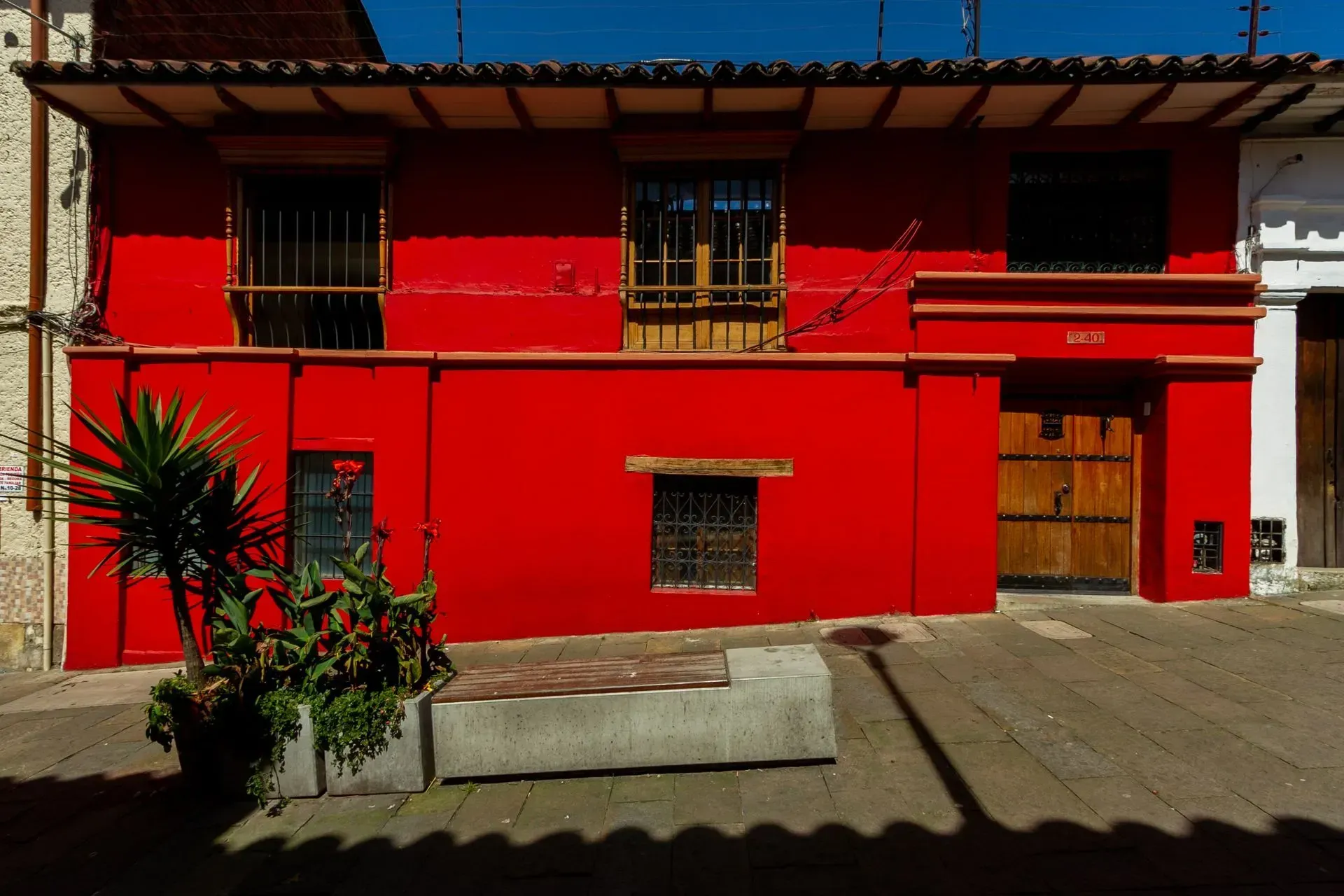 A red building with a concrete bench in front of it