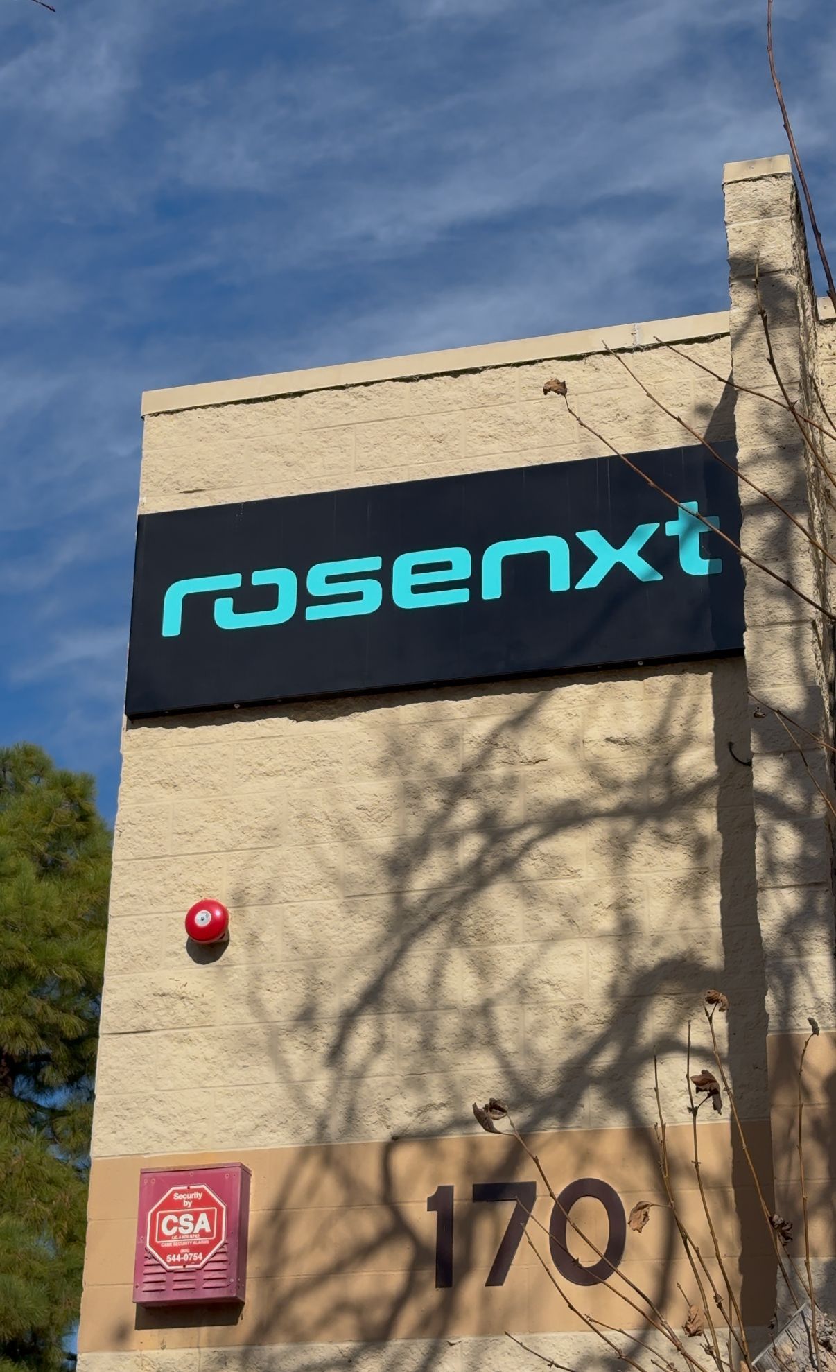 Turquoise Rosenxi sign on a beige building under a blue sky, with address 170 visible