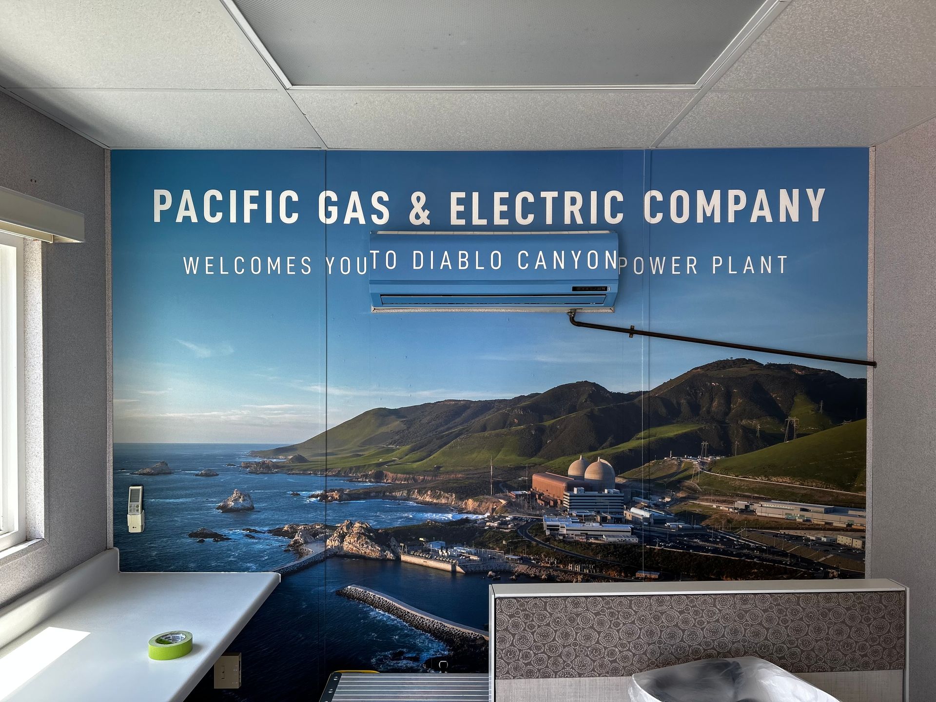 Pacific Gas & Electric Company sign welcoming visitors to Diablo Canyon Power Plant, with coastal view