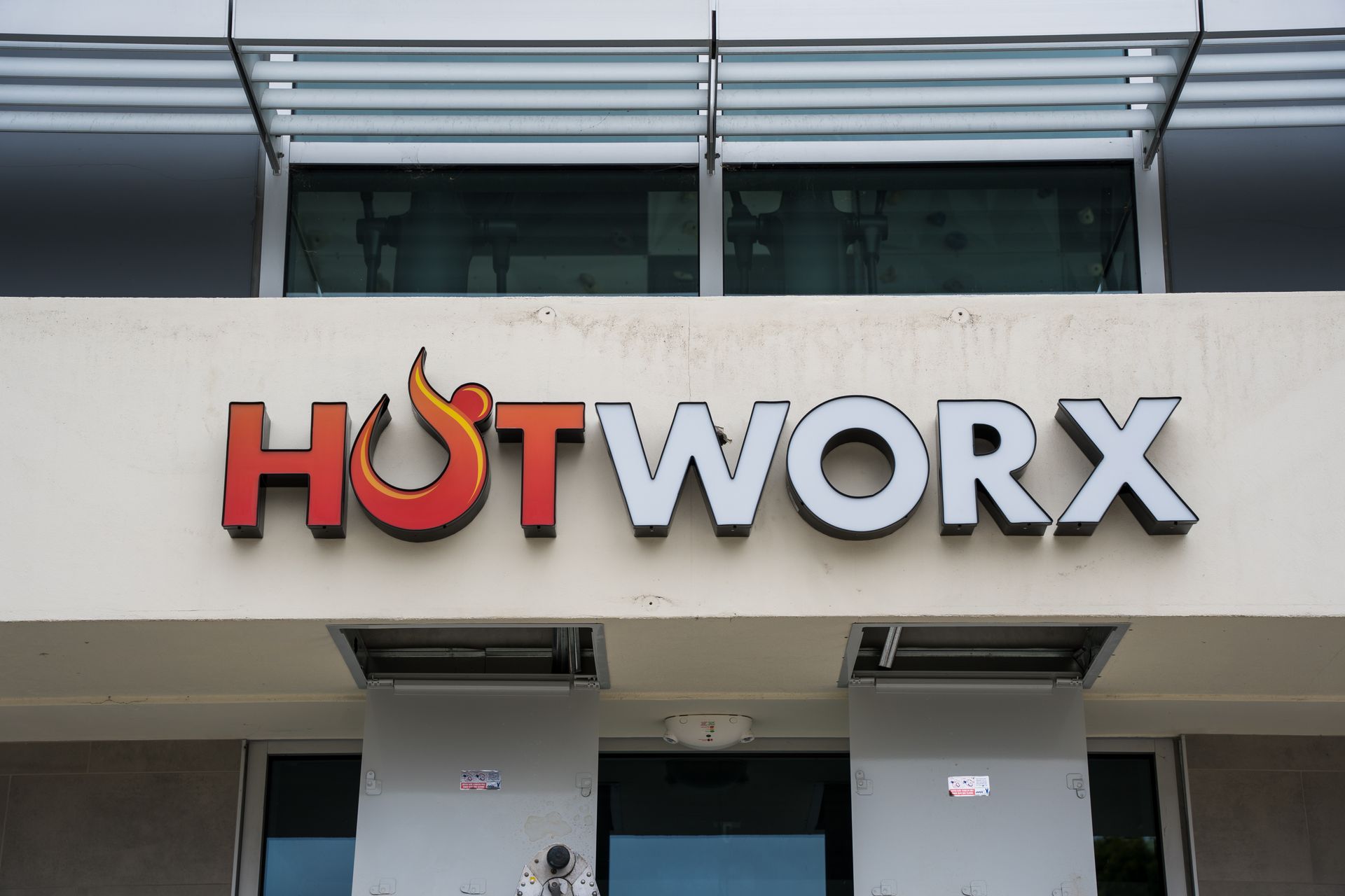 HOTWORX storefront sign in red, black, and orange on a building facade