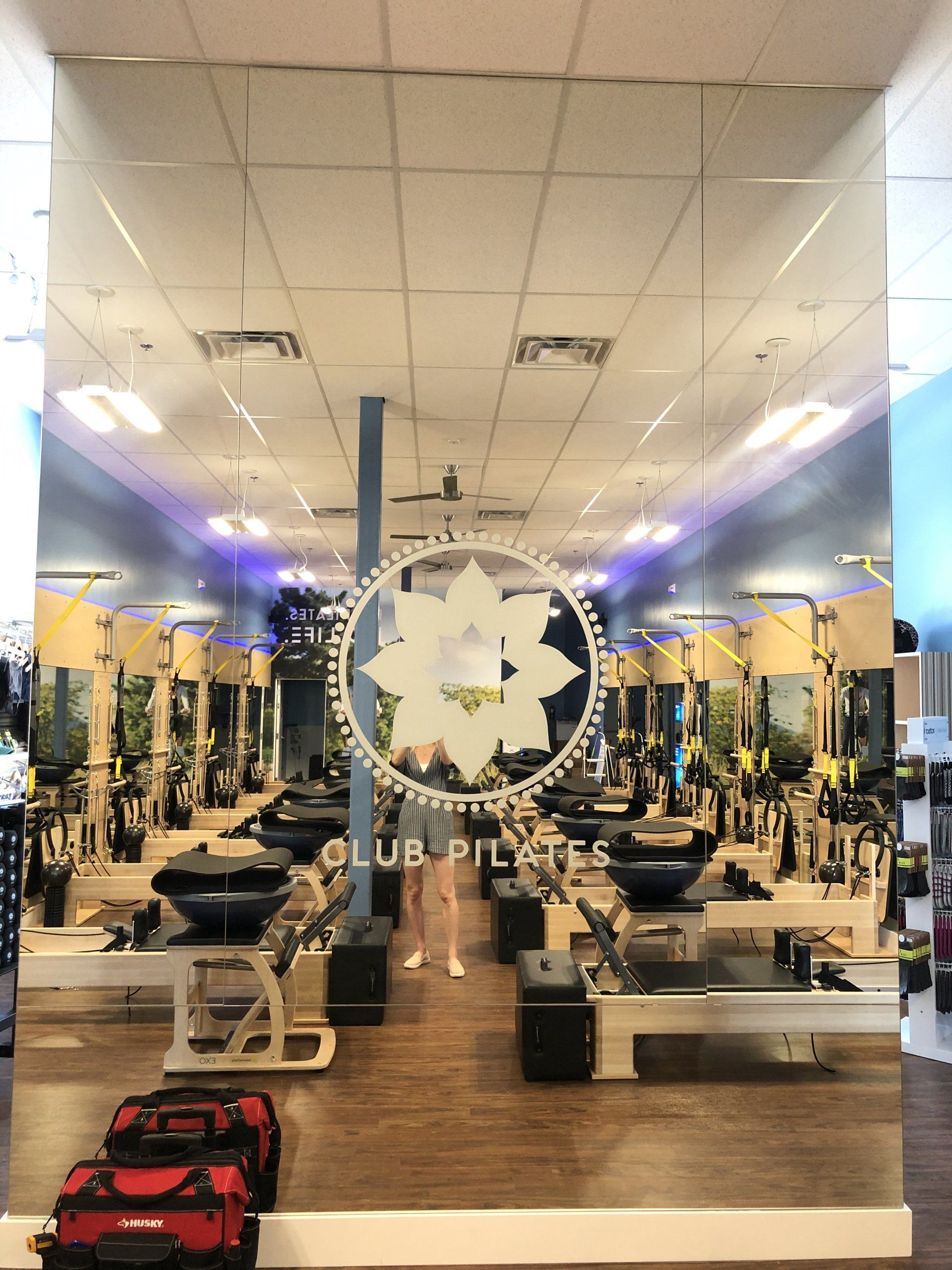 Gym interior with mirrored walls, weight machines, and red equipment bags on the floor