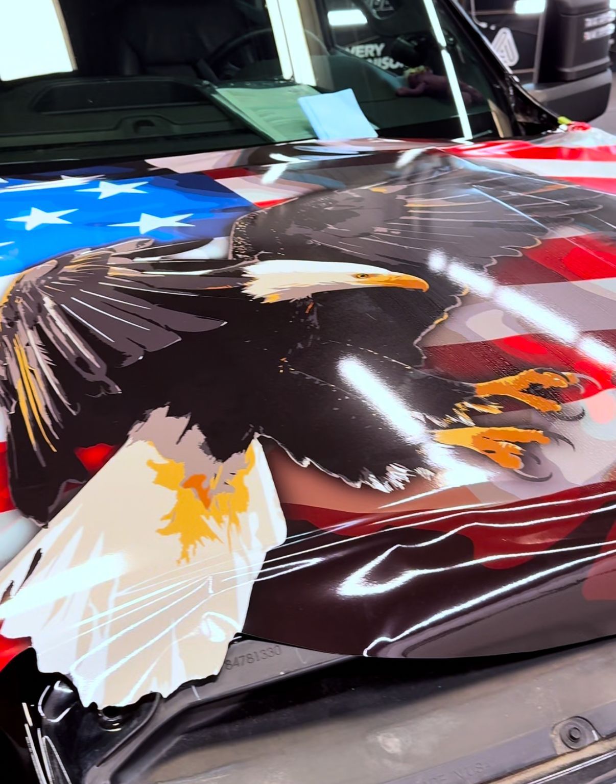 Car hood wrapped with a bald eagle and American flag design
