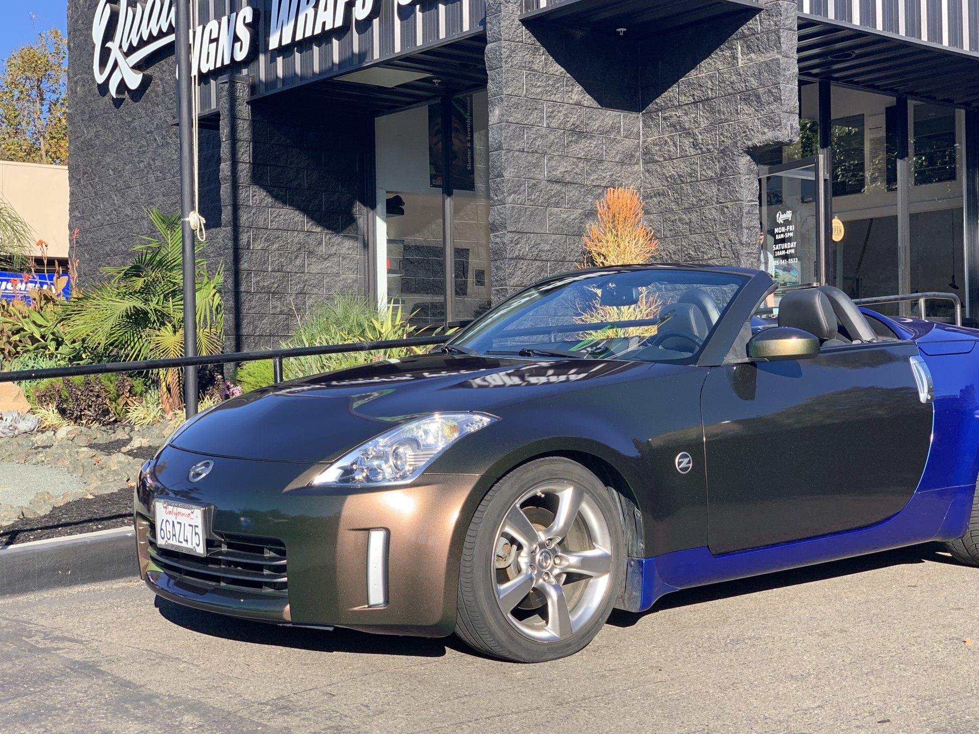 Black sports car parked outside a restaurant on a sunny day