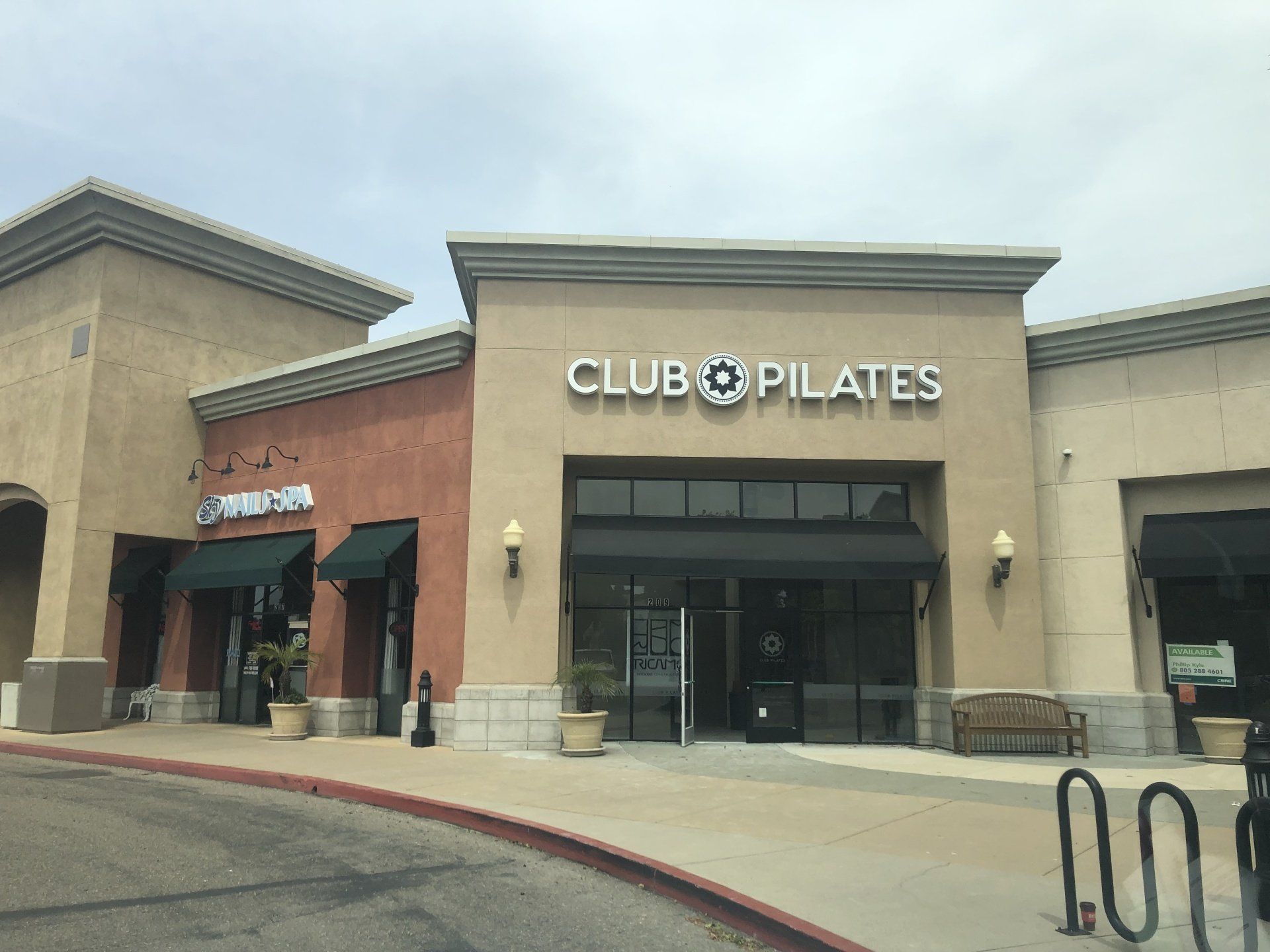 Club Pilates storefront in a tan shopping center with black lettering and glass entrance