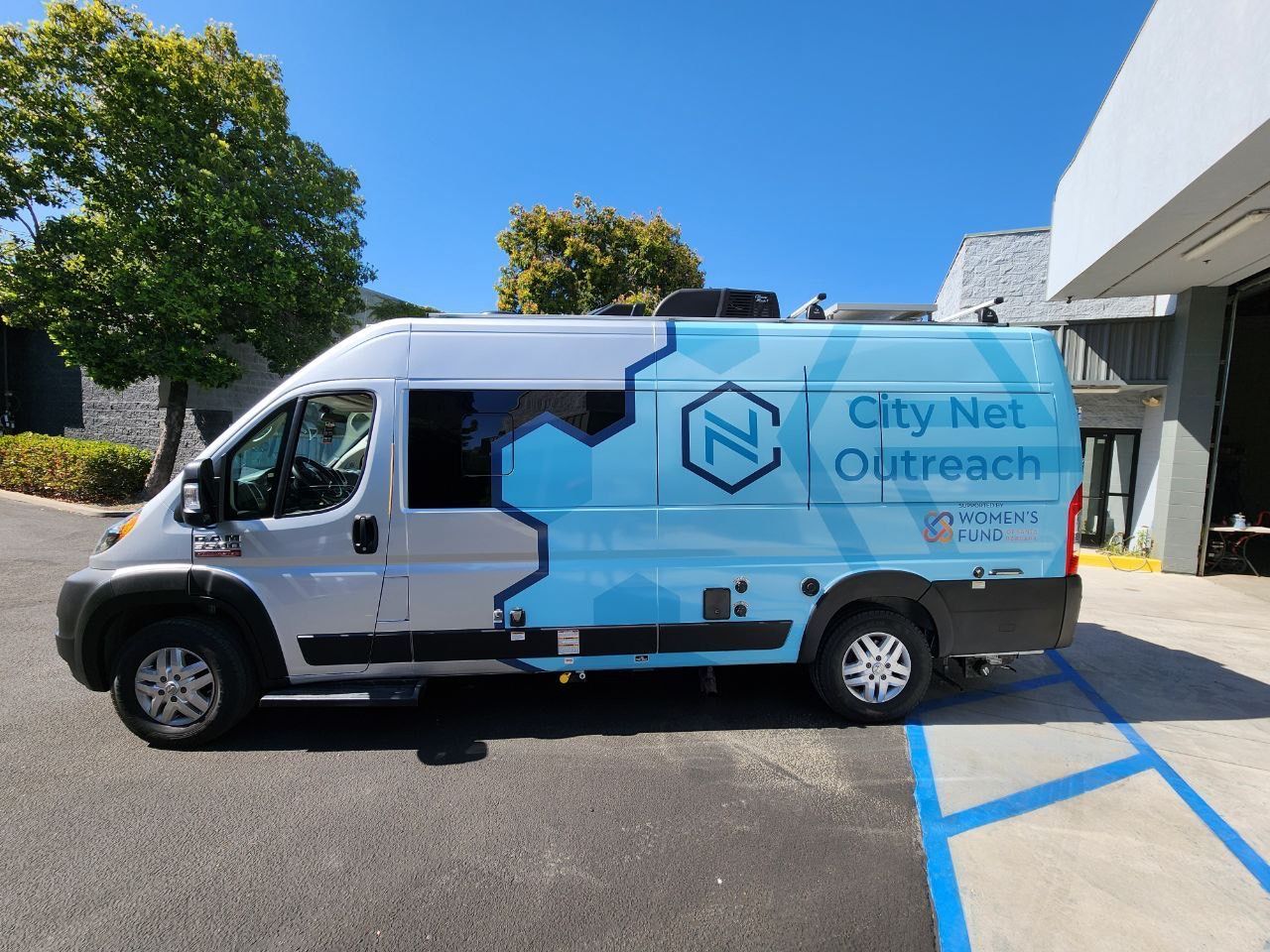 White City Net Outreach van parked outside a building on a sunny day.