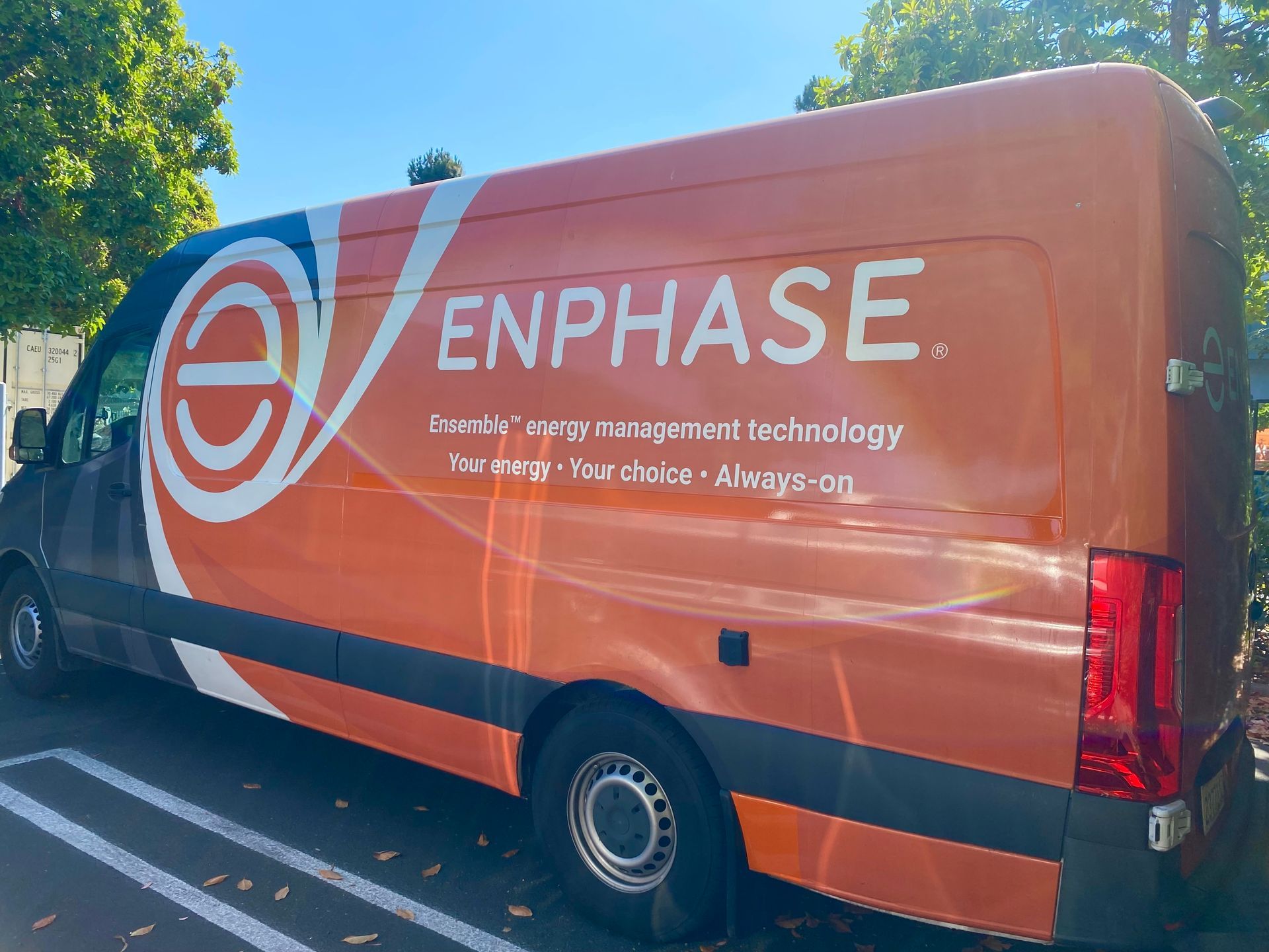 Orange Enphase branded van parked outdoors on a sunny day