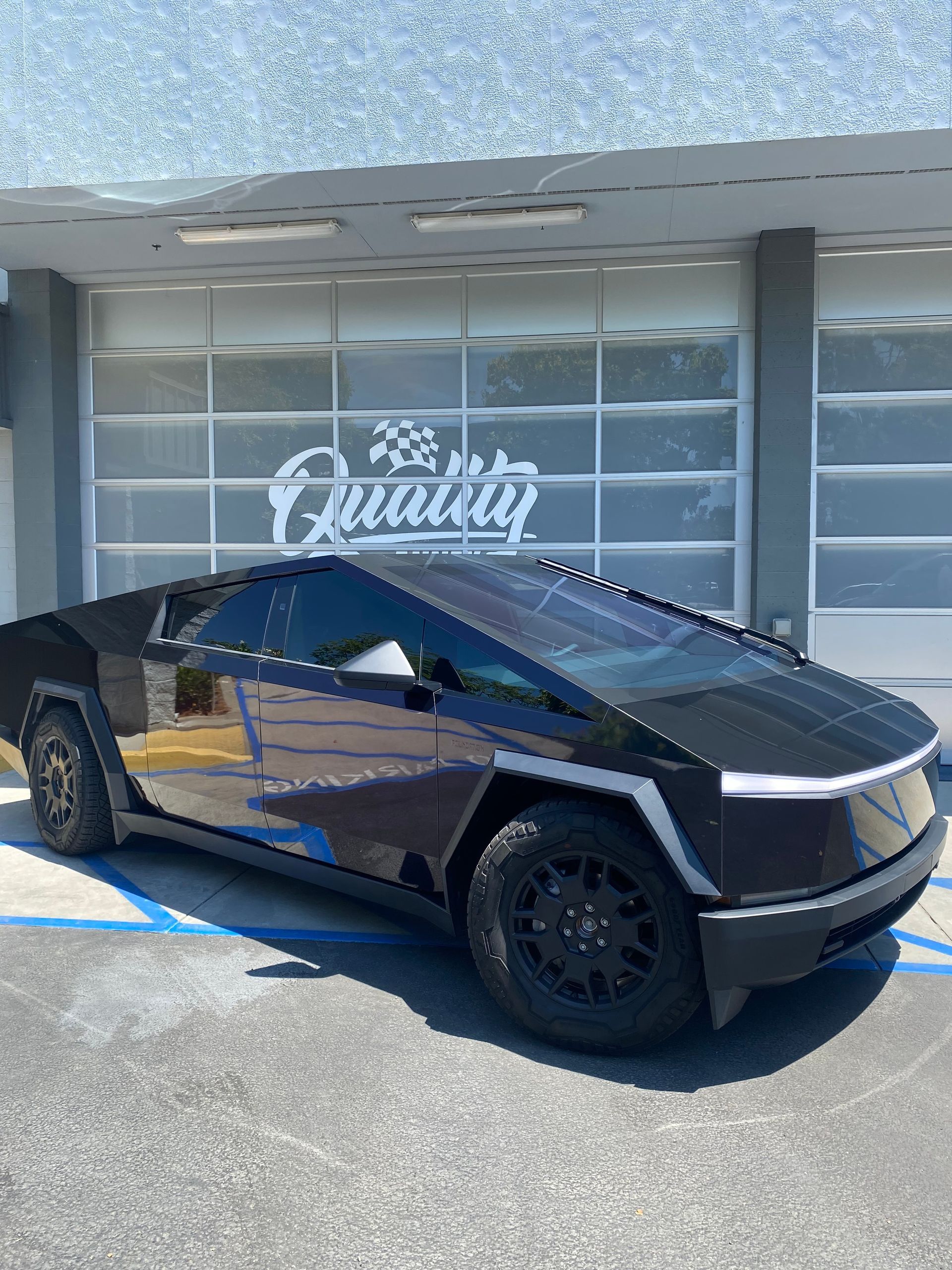 Black Tesla Cybertruck parked outside a building with a “The Quarry” sign