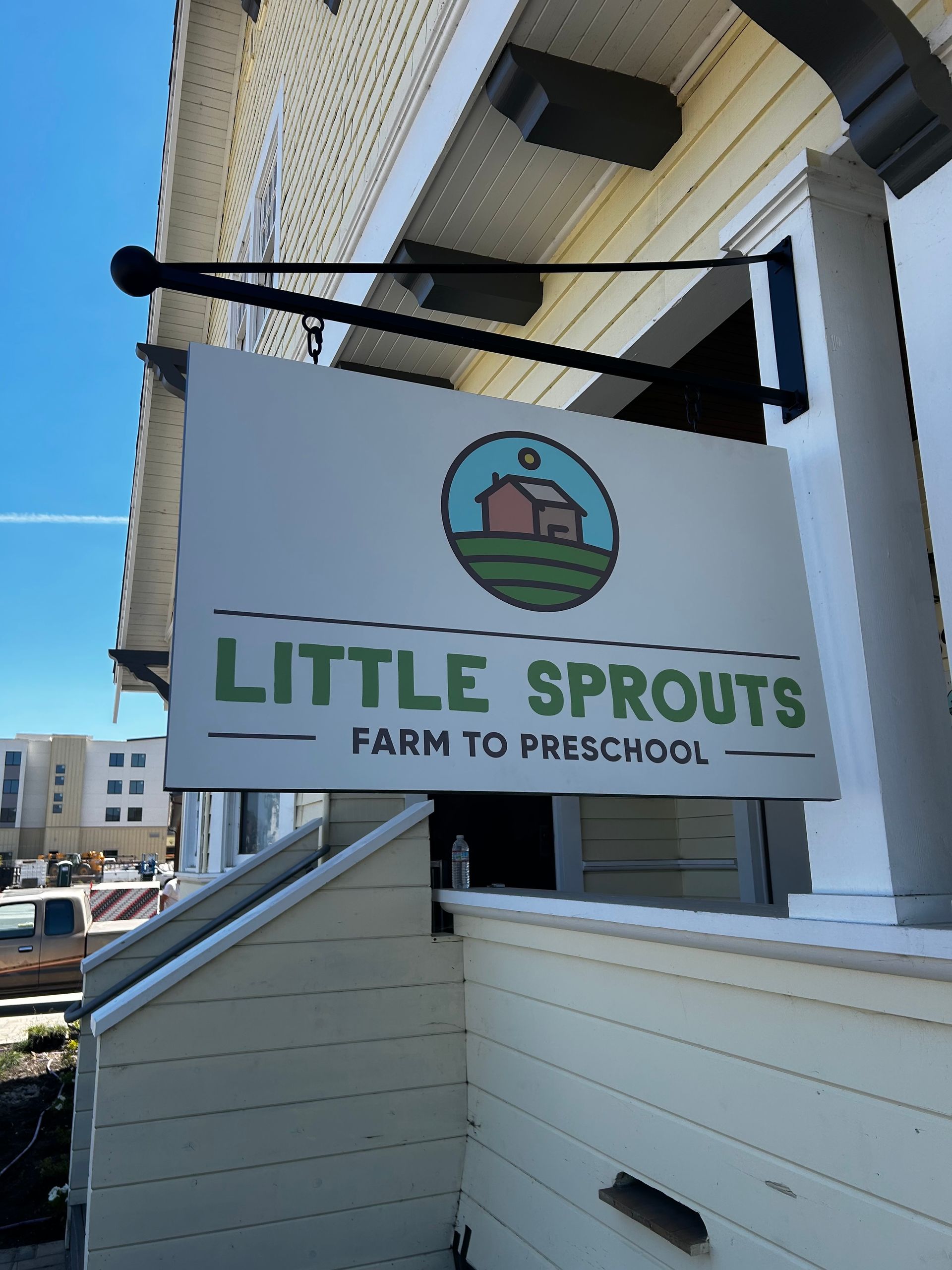 Little Sprouts Farm to Preschool sign hanging outside a white building