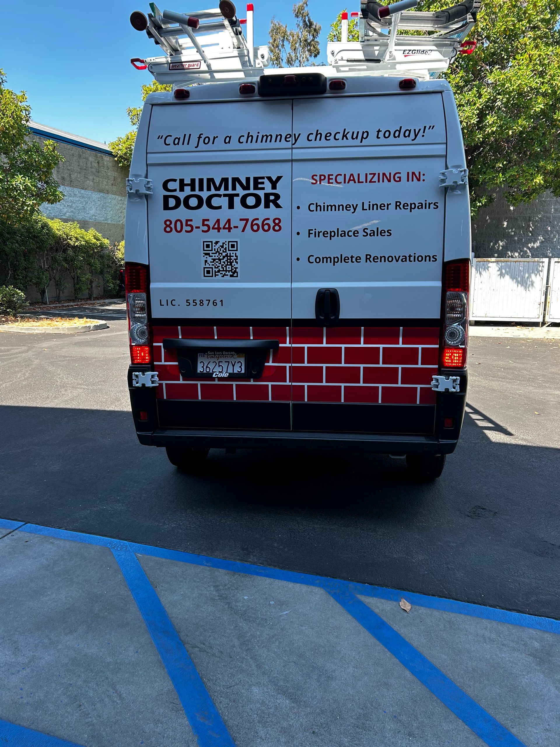 Chimney Doctor service van with ladder racks parked in a lot, rear view.